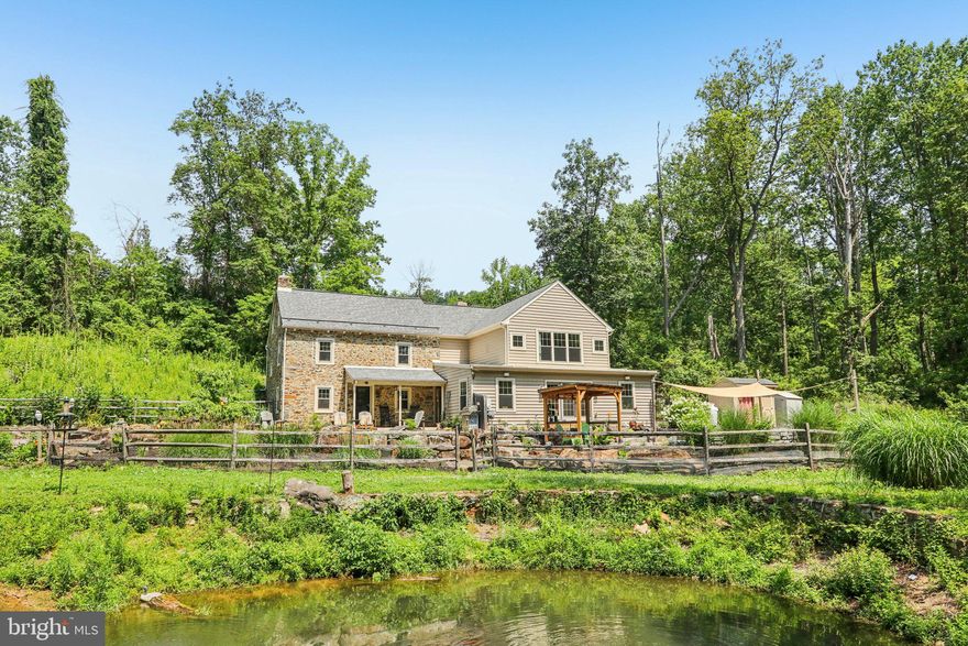 Welcome to Bog Turtle Farm, a historic Pennsylvania estate set on 24+ acres of pristine woodlands in Williams Township, where classic elegance is seamlessly integrated with contemporary amenities. This serene property features streams, koi pond, saltwater pool and spacious event barn. At its heart is a meticulously maintained stone farmhouse with original exposed beams and wide-plank floors. The updated kitchen includes stainless steel appliances, a center island and a farmhouse sink with Mercer tile, opening to a dining room with a wood-burning fireplace and built-ins. Additional main-level highlights include a stone-walled den with a wood stove and slate flooring, a large living room with French doors opening to the private outdoor area, a home office, a half bath and a mudroom. Upstairs, the primary bedroom offers a walk-in closet and ensuite with dual sinks, a jetted tub and walk-in shower. A 2nd bedroom, hall bath with clawfoot tub and laundry room complete this level, with a charming 3rd bedroom on the top floor accessed by a wooden staircase. Outdoor features include an in-ground saltwater pool and loggia. The historic barn houses a two-bay garage and workshop, plus a large upper level for events or creative use. Modern upgrades include a brand-new geothermal HVAC system and a backup generator ensuring efficient year-round comfort and peace of mind. Bog Turtle Farm offers peaceful surroundings with both eco-friendly living and convenient access to NYC and Philadelphia.