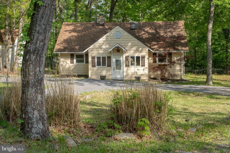 3-bedroom cottage in Shawneeland offering great potential to make it your own. Recent updates include new kitchen cabinets, countertops, updated bathroom vanities, modern fixtures, and some interior painting, providing a solid starting point for your vision.  Inside, you’ll find a warm and functional layout featuring cathedral ceilings, hardwood flooring in most of the home, and a cozy stone fireplace with gas logs. The main level includes a primary bedroom with a full bathroom, a second bedroom, and a  half bathroom. Dual loft spaces offer flexible options for a third bedroom, home office, or additional storage. The outdoor space includes a rear deck and patio, a storage shed, and a horseshoe driveway that allows for ample parking.  This home presents a wonderful opportunity for someone looking to add their own finishing touches. Enjoy access to community amenities such as lake with beach access, fishing pond, playgrounds, and picnic areas , all while being just a short drive to downtown Winchester, Virginia.