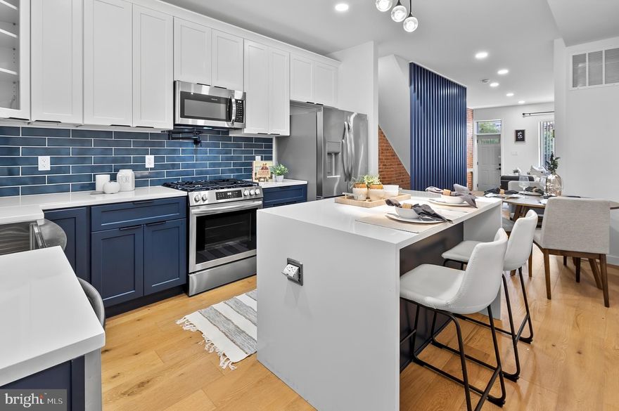 Welcome to 3306 E Lombard Street — Where High Design Meets Everyday Comfort This fully renovated 3-bedroom, 3.5-bath rowhome in East Baltimore checks all the boxes for a buyer who wants stylish finishes, smart design, and walkable city living without the noise or hassle. 
Step into a sunlit main level featuring rich hardwood floors throughout, a sleek electric fireplace, and a modern metal slatted accent wall that brings personality to the space. The kitchen is a true showpiece, designed for both beauty and function — complete with a dramatic waterfall island, drawer storage, and custom lighting that creates the perfect mood for anything from brunch to wine night. Upstairs, you'll find two spacious bedrooms, each with ceiling fans and great closet space, plus two full bathrooms with automatic lighting and high-end finishes. The top floor even includes a private deck — perfect for enjoying your morning coffee or watching the sun set over the city. The fully finished basement offers a third bedroom, another full bath, and a flexible space ideal for guests, a second living room, or your dream home office setup. 
A convenient half bath on the main floor makes entertaining easy, and every detail in this home feels thoughtful and elevated. While the home offers street parking, you'll quickly fall in love with the walkable neighborhood, where Patterson Park, local cafes, shops, and restaurants are just minutes away. This block is quiet, charming, and ideal for anyone craving a mix of city energy and personal peace. 
Best of all, this home qualifies for Baltimore City grants for first-time buyers, making it a smart and stylish move for your future. Ready to fall in love? 
Schedule your private tour of 3306 E Lombard Street today.