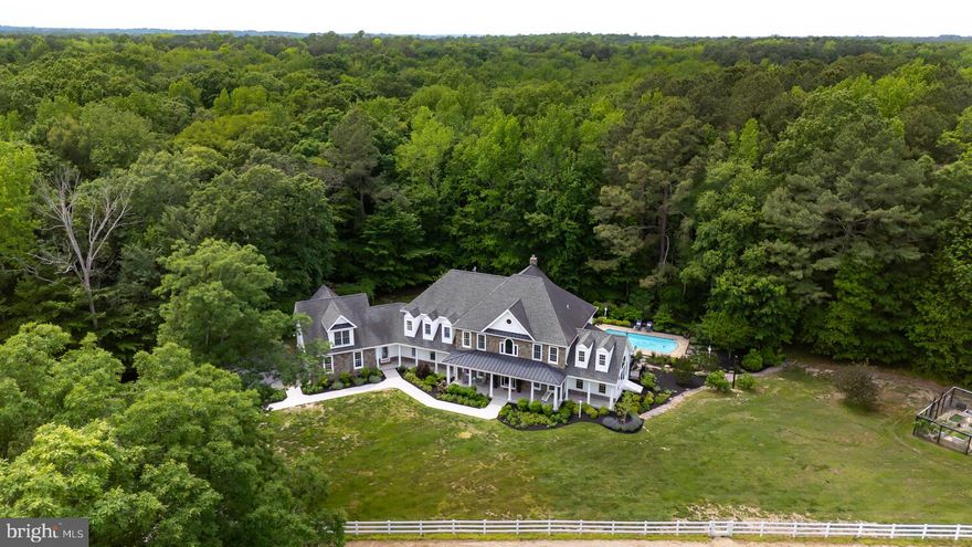 Welcome to 200 Green Farm Lane, a stunning Colonial estate offering refined living and serene seclusion on approximately 18 acres across two adjoining parcels. Tucked away at the end of a private lane this exquisite 6,500+ sq ft residence blends timeless elegance with modern functionality. Inside, you'll find five spacious bedrooms, five and a half baths, and thoughtfully designed living areas, including a formal living room with hardwood floors, wainscoting, and a stone-surround fireplace, as well as a great room with coffered ceilings and fireplace, vaulted conservatory, sunroom with wood stove, and a third-floor “speakeasy” media room. The gourmet kitchen features high-end stainless appliances, a large center island, granite countertops, ample table space, custom cabinetry, and a walk-in pantry. The main level also offers a guest suite, office, and formal dining room. The second floor includes four additional en-suite bedrooms, including a luxurious primary suite with heated bathroom floors, clawfoot soaking tub, separate shower, gas fireplace, sitting area, and a renovated walk-in dressing room. Additional features include a finished bonus room above the three-car garage, four-zone HVAC (updated in 2024), pre-wired tech systems including new Sonos sound system in the lower level, expansive porches, three rear decks, and an in-ground saltwater pool (installed 2016), surrounded by professional landscaping and native gardens. See full list of upgrades in documents. Equestrian amenities include two barns with electric and wash areas, a 40 ft round pen, and paddocks with electric fencing. This exceptional property offers the rare combination of privacy, natural beauty, and top-tier craftsmanship—an Eastern Shore retreat just minutes from town yet worlds away.