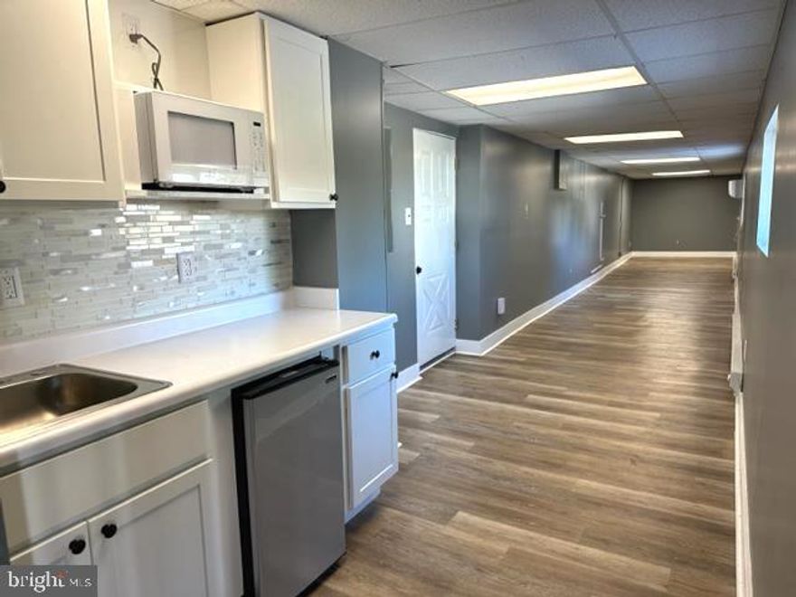 AFFORDABLE AND UPDATED OFFICE SPACE LOCATED IN A HIGHLY VISIBLE BUILDING!  This unit is located at the rear of 8330 Pulaski Hwy and offers an updated office space with wood laminate flooring, an updated kitchenette, a half bath, and plenty of parking!  Triple Net Lease
