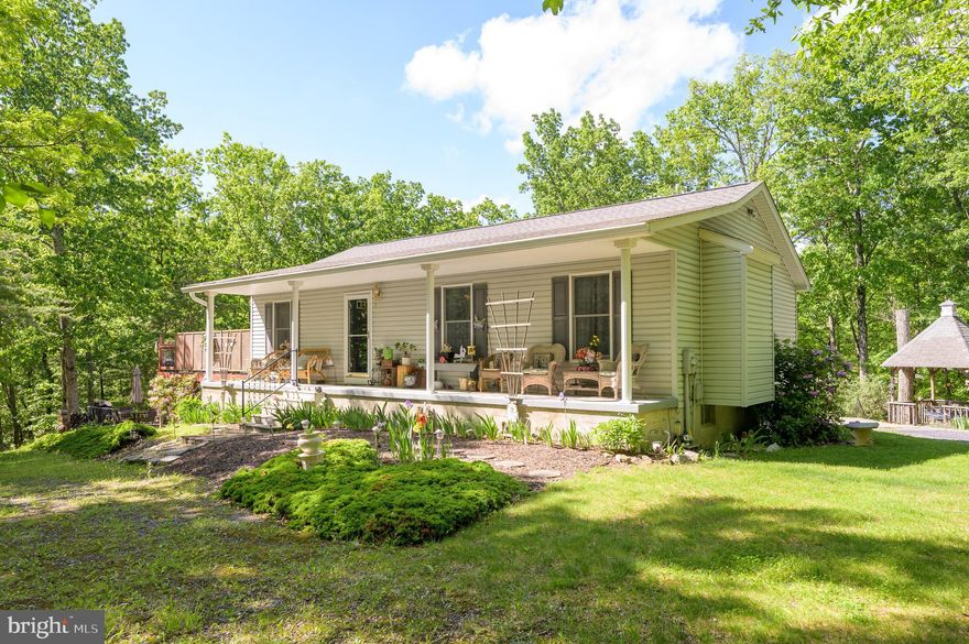 A cozy Rancher home nestled in the woods. 3 Bedrooms, 2.5 Baths. Open floor plan. Unfinished basement. 
5.01 acreage. Attached 2 car oversized garage with wood stove. Laundry room off kitchen. Front porch and 2 side decks. Patio.  Hot tub and fire pit. 2 sheds. Outside furniture and grill convey with the property. No active HOA. Heat pump comes with a warranty. 2.01 of the 5.01 acres is deeded separately. You could possibly build another home on the 2.01 acres. A lot of potential.