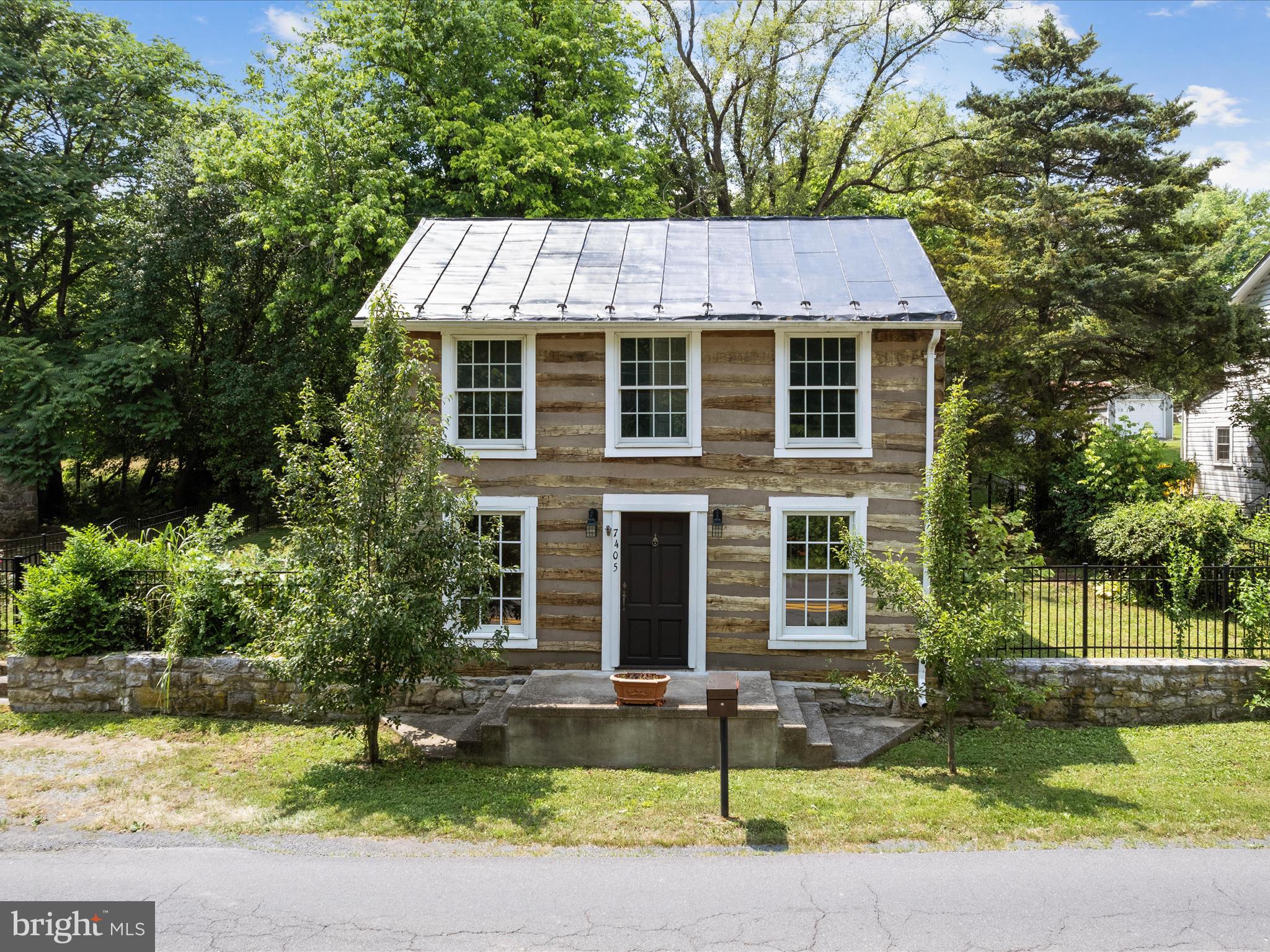 Price Reduced! Charming historic log cabin with oversized garage/workshop + studio space!
Set in the heart of Middleway’s historic district, this 2-bed, 2.5-bath log home offers timeless character and modern convenience on nearly half an acre. The standout detached garage includes electric, workshop space, and direct street access—perfect for a studio, hobbyist, or home-based business. The home features a standing seam metal roof, exposed log walls, a spacious living room with wood floors, and an eat-in kitchen with heated tile floors and stainless appliances. A main-level laundry and half bath add functionality. Upstairs, a generous loft connects two large bedrooms, each with its own full bath. Outside, enjoy a fully fenced yard that backs to mature trees, a storage shed, and plenty of room to garden or relax. With its rich 18th-century charm, peaceful setting, and convenient access to Winchester, Leesburg, and Northern Virginia, this is a unique opportunity to own a piece of West Virginia history.