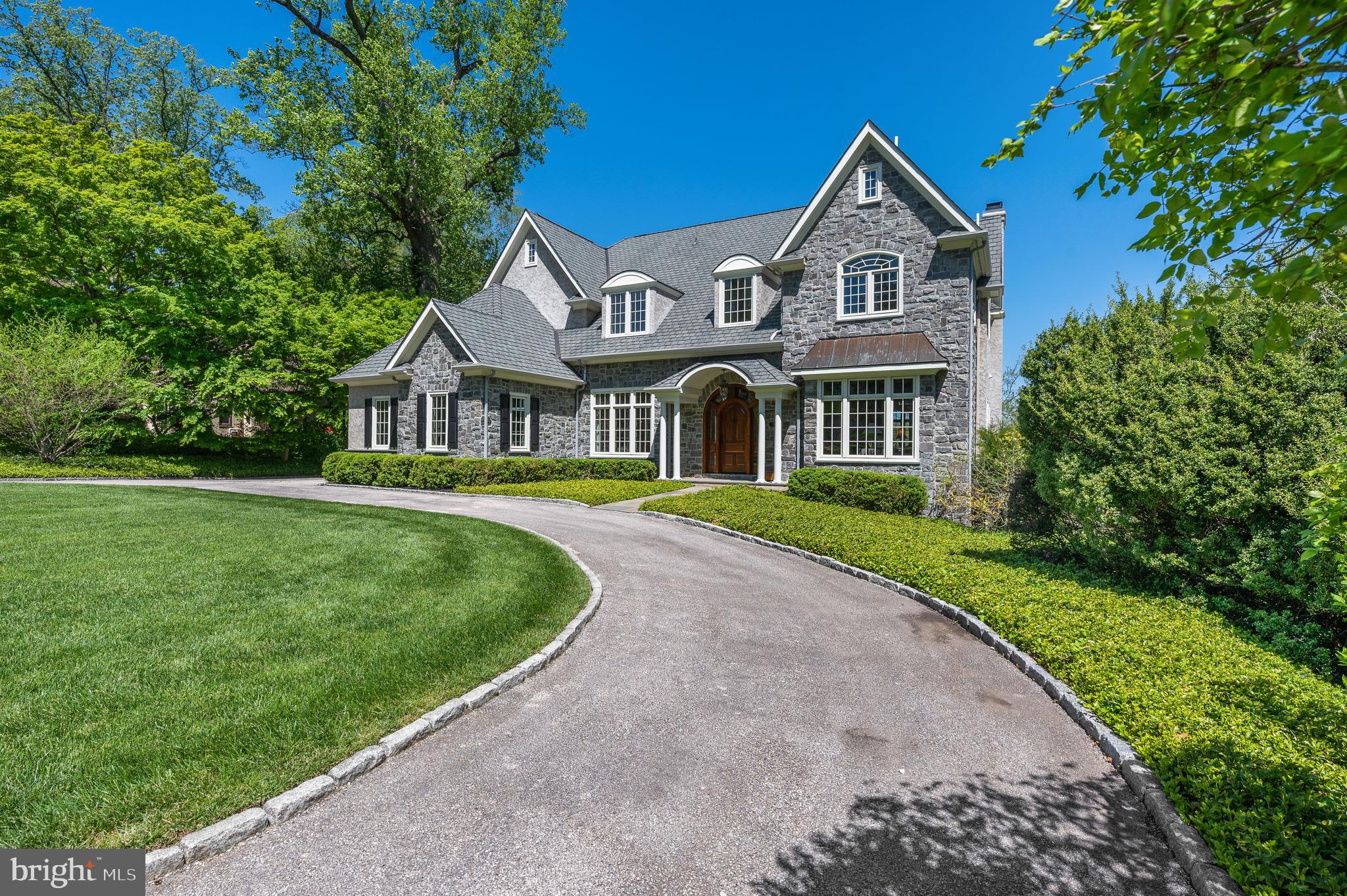 Where will you be watching the 2030 U.S. Open? Perhaps from the comfort and joy of 234 Golfview Road- Perfectly situated on a hill overlooking the 11th Fairway and the famous 11th Green where Bobby Jones clinched his Grand Slam in 1930. This custom home designed by Peter Batchelor was built in 2005 and combines the charm and grace of Merion Golf Manor with the conveniences of a modern, open floor plan. Substantial millwork, arched cased openings and hardwood floors are found throughout the home.
Enter through the custom mahogany front door into a grand, two-story foyer with open stairway and custom paneling, flanked by a formal Dining Room and handsome Study. Beyond the Foyer, you immediately enter the light filled Great Room with a wall of windows overlooking Merion Golf. This open space with custom built-ins and gas fireplace provides easy access to the expansive outside terrace, wet bar and kitchen, providing perfect flow for entertaining. The kitchen boasts custom Kountry Kraft cabinetry, granite countertops with built-up edge detail, gourmet Viking and SubZero appliances, oversized island, perimeter prep sink and a hidden message center with walk-in pantry. Open to the kitchen, is a generously sized breakfast nook with stone fireplace and seating area, perfect for enjoying the views with a morning cup of coffee. Powder Room with marble floors and a mudroom off the 2 car garage round out the main floor of this incredible home. The second floor includes four generously sized bedrooms, three full baths and an oversized laundry room with plenty of space for an art studio, crafting or other hobbies! The primary bedroom suite includes two walk in closets and five piece bathroom with heated floors, his & hers vanities, walk in shower, oversized soaking tub and separate water closet. The 2nd bedroom feels like another primary suite with an abundance of space and an ensuited full bathroom. Two additional bedrooms with a Jack and Jill bathroom complete the 2nd floor. The lower level is not to be missed! With almost 1500SF of finished space, including exercise room, half bath, home theater and expansive game room, there is plenty of opportunity to customize the space to your needs. Don't forget the lovely walk out slate terrace that once again connects you to the mature landscaping, perimeter paths and expansive decks that overlook Merion Golf. The home also includes a central vac system, sound system and the opportunity to add an elevator from the garage to 2nd floor should the need arise. Schedule your appointment today!