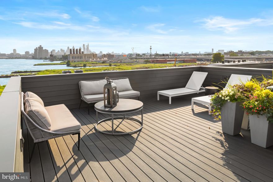Stunning river views! Former model home, fully loaded! Welcome to this 3800 square foot end unit townhome, nestled on the picturesque Delaware River at Northbank. This exceptional 4-bedroom, 3 full, 2 ½ -bathroom townhome boasts a remarkable blend of elegance, comfort, and waterfront living. As you step inside, you'll be greeted by a bright and airy open floor plan, adorned with large windows that allow natural light to flood the space. The first floor has an abundant office space, ½ bath, equipment closet, coat closet and garage access.  The second level features a spacious living room with 10’ ceilings, 8’ windows, and a side balcony, perfect for entertaining guests or relaxing with family. The gourmet kitchen is a chef's dream, equipped with high-end stainless steel appliances, including 36” Wolf range, Sub Zero refrigerator, quartz countertops, and ample cabinet space. Dining area with a dry bar, including wine cooler and a ½ bath.  The three additional bedrooms provide plenty of space for family members or guests, each with its own unique charm. Two bedrooms share a hall bath with tub and a third bedroom with a private ensuite bath with tile shower. Also, on this floor is the laundry room with cabinets above and mechanical closet. Make your way to the upper level, where you'll find a generously sized owners suite, a true sanctuary. Complete with a custom walk-in closet and a luxurious ensuite bathroom, featuring a soaking tub, separate shower, and double vanity. The fourth floor also features a wet bar and open area with room for a living area, gym or office with a walkout balcony. Rooftop deck with Trex decking, outdoor lighting, speakers and full outdoor kitchen with electric grill. This end unit offers breathtaking views of the Delaware River from multiple vantage points, North to Graffiti Pier, South to the Ben Franklin Bridge and East across the Delaware River to Petty Island (a nature preserve). Imagine sipping your morning coffee while watching the boats sail by or enjoying a sunset dinner with loved ones. The tranquil surroundings create a serene atmosphere, perfect for unwinding after a long day. Additional highlights of this exceptional home includes a Brick front, Pella windows, Energy Star certification, 2 zone HVAC, remaining 8-years tax abatement, Smart home wiring, a convenient laundry room, and an oversized two-car garage for your vehicles and storage needs. The Northbank community offers an array of amenities, including several parks and walking trails, providing endless opportunities for relaxation and recreation. Located in close proximity to shops, restaurants, and major highways, this Essex model end unit offers the perfect balance between a peaceful riverside retreat and easy access to modern conveniences. Don't miss the opportunity to experience waterfront living at its finest in this exquisite townhome.