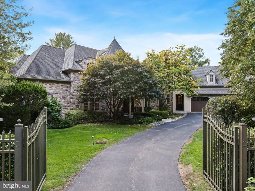 Elegant gated estate in sought-after Gladwyne, masterfully designed by renowned architects Peter Batchler alongside architectural designer, Christina Waters, offering exceptional craftsmanship, scale, and versatility. A grand two-story marble foyer with a sweeping curved staircase makes a striking first impression and opens to the spectacular great room, highlighted by soaring ceilings, a Heat & Glo gas fireplace, and custom built-ins with a lighted display and media center. This impressive space flows seamlessly into the chef’s kitchen, featuring rich custom cabinetry, an oversized center island with seating, and top-of-the-line stainless steel appliances, including a Thermador cooktop, a new refrigerator, double dishwashers, wall ovens, and a Sub-Zero wine and beverage refrigerator. A sun-drenched breakfast area with built-in bench seating overlooks the serene, private grounds. The stunning sunroom serves as a true indoor-outdoor retreat, complete with multiple seating areas, a dining space, hurricane-rated windows, and a full indoor grilling kitchen perfect for year-round entertaining, all with picturesque views of the lush backyard. The formal dining room, adorned with elegant crown molding, is ideal for hosting and is complemented by a well-appointed butler’s pantry. Additional main level highlights include a richly detailed home office with custom built-ins, two powder rooms, multiple pantry closets, and a spacious, well-equipped laundry room. The luxurious first-floor primary suite offers a private sanctuary, complete with a Heat & Glo gas fireplace, custom built-ins, and an expansive, professionally outfitted walk-in closet. The spa-inspired primary bath features dual vanities, separate water closets, a soaking tub, and an oversized glass-enclosed shower. The second level offers two generously sized bedroom suites with ensuite baths, along with two additional bedrooms connected by a Jack-and-Jill bathroom. A standout feature is the fully self-contained one-bedroom apartment with both private exterior access and interior connectivity, ideal for an au pair, in-law suite, or extended guests, complete with a living area, full kitchen, separate bedroom, full bath, and its own laundry. The finished walkout lower level provides exceptional additional living space, including a large media and recreation room, fitness area, full bathroom, a private office with exterior access, and abundant storage. Additional features include an elevator servicing all levels, an oversized four-car garage, three HVAC systems with six zones, and beautifully manicured, private grounds. Ideally located just minutes from the Village of Gladwyne with convenient access to Center City Philadelphia, major roadways, premier shopping and dining, and situated within the highly acclaimed Lower Merion School District, this extraordinary estate offers refined Main Line living at its finest.