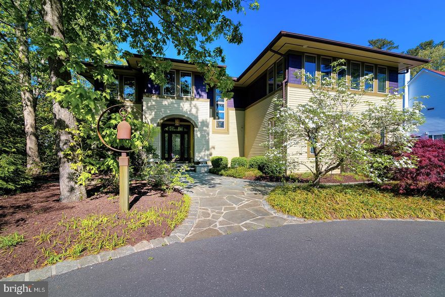 Live Where Architecture Becomes a Way of Life in Canal Corkran:  Inspired by the enduring vision of Frank Lloyd Wright and the integrity of the Arts & Crafts movement, this Prairie-style residence offers more than shelter — it offers a daily experience shaped by artistry, intention, and harmony with nature. Here, life unfolds in spaces designed to feel grounded and serene. The heart of the home is an open living and dining space anchored by a substantial fireplace — a natural gathering place in every season. The kitchen blends heritage character with modern ease: double ovens, dual dishwashers, a generous island, butler’s pantry, and adjacent laundry make entertaining effortless and everyday living beautifully efficient. Upstairs, treetop views set the tone for quiet mornings in the library, cinematic evenings in the media room, and restful nights in spacious bedrooms designed for comfort and retreat. The primary suite feels like a private sanctuary, complete with custom closets, a sun-washed ensuite bath, and a large deck that invites slow starts and peaceful evenings. Outdoors, the lifestyle continues. A covered screened porch extends the living space year-round. A saltwater pool and separate hot tub offer resort-style relaxation. Manicured landscaping and a serene garden provide the perfect setting for morning coffee, afternoon reading, or al fresco gatherings under the stars. The home’s low-pitched rooflines, generous overhangs, and strong horizontal presence create an immediate sense of calm, anchoring you to the landscape. Earth-toned stucco, handcrafted stonework, and rich wood details echo the natural surroundings, making every arrival feel like a retreat. Inside, craftsmanship defines the atmosphere. Thoughtfully curated hardware and fixtures from Milwaukee Brass Company lend authenticity and quiet sophistication to every room. Handmade Arts and Crafts lanterns cast a warm amber glow in the evenings, enhancing the depth of the original millwork and built-ins — a setting equally suited for intimate dinners or relaxed family nights. Expansive custom art glass windows — designed in the spirit of Wright’s iconic aesthetic — filter in soft natural light while preserving privacy. The effect is both uplifting and tranquil, creating a seamless dialogue between indoors and out. Set within the private neighborhood of Canal Corkran with its own community pool, the location enhances the experience even further. From your front door, you can walk or bike to downtown Rehoboth Beach, where charming boutiques, acclaimed dining, and vibrant entertainment await. Miles of pristine coastline are just moments away, inviting sunrise strolls and sunset swims, while nearby outlet shopping provides effortless convenience for everyday needs and indulgent finds alike. For those drawn to architectural heritage, artisan craftsmanship, and coastal living with distinction, this Prairie-style masterpiece offers something rare: the chance to inhabit art — and to make everyday life extraordinary.