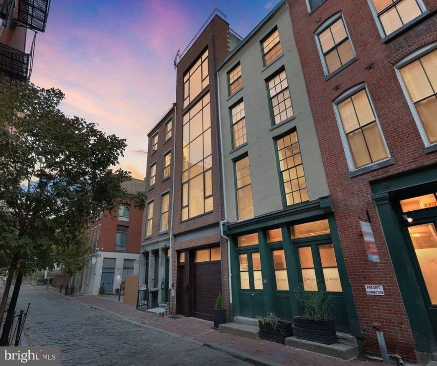 A one-of-a-kind architecturally distinctive home tucked along a quiet cobblestone block in the heart of Old City. Welcome to 218 Church Street (approx. 3450 sq. ft.) with three glorious bedrooms, three full bathrooms and  a powder room, steps away from wonderful restaurants, historic landmarks, chic boutiques, The Arden Theater and Christ Church. The residence was designed by Janice Woodcock & Associates and built in 2005.   From the moment you arrive, the striking glass façade sets the tone for this extraordinary four-story home. The first level combines function and flexibility, featuring a two-car, temperature-controlled tandem garage, a fitness/yoga studio, a full bathroom, abundant storage, a wine cellar with N’Finity SC3000 Whisperkool. climate control system and even a Murphy bed—perfect for overnight guests. Ascending the stairs wrapped in glass, you’re welcomed into the home’s dramatic centerpiece: a soaring 40-foot atrium crowned by a massive skylight that fills the space with natural light. Off this central hub, the chef’s kitchen impresses with custom lacquered cherry cabinetry, Viking appliances, sleek black granite counters, a large island, and a generous dining area.  Step directly onto the adjoining deck—an inviting outdoor retreat for morning coffee or an evening cocktail.  A stylish powder room is located on this floor and convenient for your guests.  The expansive living room offers an unforgettable backdrop for entertaining, showcasing 22 feet of floor-to-ceiling glass, and remarkable ceiling heights. Overlooking the living space is a lofted perch with a cozy gas fireplace ideal for mingling during parties or enjoying a quiet reading nook. On the opposite side of the central atrium are two generously sized bedrooms that could also be used for offices and a gorgeous full bathroom with handsome stone finishes and a glass vanity.  The upper level is entirely dedicated to the primary suite, offering a private sanctuary with dramatic proportions and thoughtful design. The bedroom boasts incredible natural light, treetop and skyline views, and a generous layout that easily accommodates both sleeping and sitting areas.  The primary bedroom chamber/space located in front of the home, features a large floor to ceiling window which completes the curtain wall effect from the exterior of the home. The spa-inspired primary bathroom features a custom vanity, Calacatta Borghini Carrara marble, a Japanese soaking tub, and a massive glass-enclosed shower, creating a serene retreat.  Crowning the residence is a rooftop deck with breathtaking panoramic views—from The Ben Franklin Bridge to the Center City skyline, the Delaware River and the surrounding historic neighborhood. This space is perfect for entertaining, dining under the stars, or simply enjoying quiet moments above it all.218 Church Street is more than just a home—it’s a rare opportunity to own a work of art in one of Philadelphia’s most iconic neighborhoods.