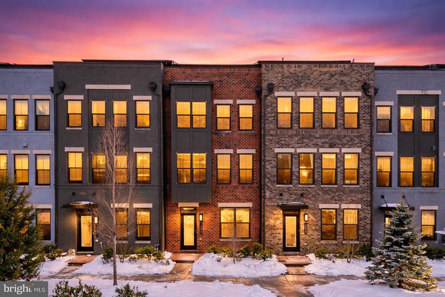 Welcome to this modern four-level townhome built in 2020 and ideally located just a short walk to the Herndon Metro station, Harris Teeter, and a variety of shops and restaurants. Delivering the convenience of city-style living with exceptional value compared to closer-in markets, this home blends contemporary design with commuter-friendly access in the heart of Herndon’s growing tech corridor.

The entry level features a private bedroom with direct access to a full bath, ideal for guests, a home office, or multi-generational living. An attached two-car garage adds everyday convenience and additional storage.

The main living level showcases an open-concept layout designed for both entertaining and daily living. The designer kitchen features a large center island, quartz countertops, tall white cabinetry with crown molding, stainless steel appliances including double wall ovens and a gas cooktop, a modern backsplash, and a farmhouse sink. The kitchen flows seamlessly into the spacious dining and living areas, creating a bright and inviting gathering space. A covered balcony just off the main level provides a comfortable outdoor extension of the living space.

The next level offers two true suites, each with its own private full bathroom, creating a highly functional and desirable layout. The primary suite features generous closet space and a spa-inspired bath with dual vanities and an oversized glass-enclosed shower. A conveniently located laundry area completes this floor.

The top level adds exceptional versatility with a spacious seating game room area, an additional bedroom, and a full bath with dual access from both the bedroom and the sitting area. Direct access to the rooftop terrace creates a private setting for relaxing or entertaining.

****Some photos have been virtually staged for illustrative purposes****