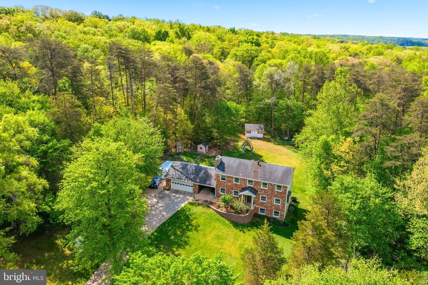 Stately brick colonial home in the secluded and sought-after Greenbrier Estates neighborhood. Situated on a private cul-de-sac, this oversized residence features 4 bedrooms, 2 full bathrooms, 2 Half bathrooms, and a 2-car garage. With over 3,400 square feet of living space on more than 5 acres, the property offers ample room for multi-generational families, including potential for an ADU, a small barn for horses, chicken coop, or parking for an RV, boat, or work vehicles. Notably, the property is zoned A1 with no HOA.

The main level offers a timeless layout with a formal dining room with a wood stove and an eat-in kitchen that flows into a family room with a large bay window. The kitchen includes a French glass door leading to a spacious deck and a beautiful yard highlighted by mature trees and a creek bed that runs through the rear of property.
The second floor contains two spacious bedrooms and a large primary suite with an updated bathroom. The walk-out lower level includes a private entrance, making it ideal for an in-law suite or tenant use. This level features an additional bedroom and bathroom, along with an entertainment area complete with an additional fireplace, bar, tap, mini-fridge, and microwave.
Conveniently located just minutes from I-95, Route 66, 28, 234, and the VRE, this home is perfect for commuters. It is also near historic Old Town Manassas, Shopping, Dining, Great Schools, the Manassas Regional Airport, and local parks like Dove’s Landing,  Prince William Forest Park which offers access to the Broad Run River.

Upgrades 
New shower upgrade in primary bath 2025
Basement bedroom remodel 2026
New attic fan 2024
Replace metal drain under drive way 2018
New ceramic cook top 2011
 New refrigerator 2021
Chimney mortar repair 2024
Leaf guard whole house 
5 new double pane windows   New French doors basement 
New furnace and heat pump 2017
New propane tank 2017
New front door with metal security frame 
Remodel main level