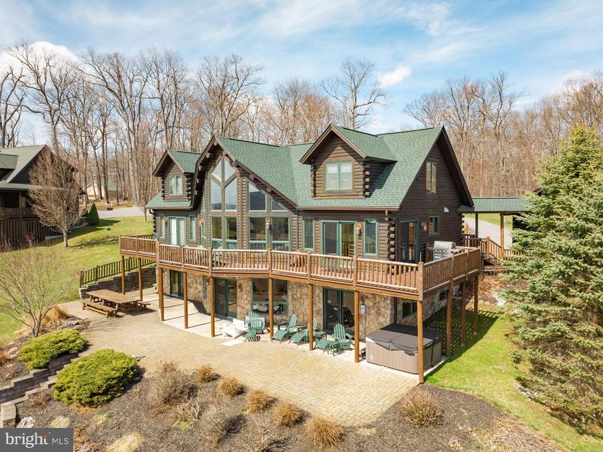 Expansive lake view log home with a blend of rustic charm and modern amenities in the Vistas of Waterfront Greens. This home offers golf, pond, lake, and mountain views, as well as lake access just a short drive away in Waterfront Greens. The open floorplan is designed to maximize the stunning views with an abundance of windows, beamed cathedral ceilings in the great room, two stone gas fireplaces, and a walkout lower-level family room. Offering five bedrooms, three and a half baths, wood flooring, an outdoor hot tub, and a sauna on the lower level. The large front deck and lower brick patio featuring a great fire pit are ideal for entertaining family and friends. The property also boasts an open breezeway to a two-car garage and a paved driveway. This would be an ideal permanent residence or vacation rental. Established rental and located just minutes to area amenities. Call today to preview this stunning home!