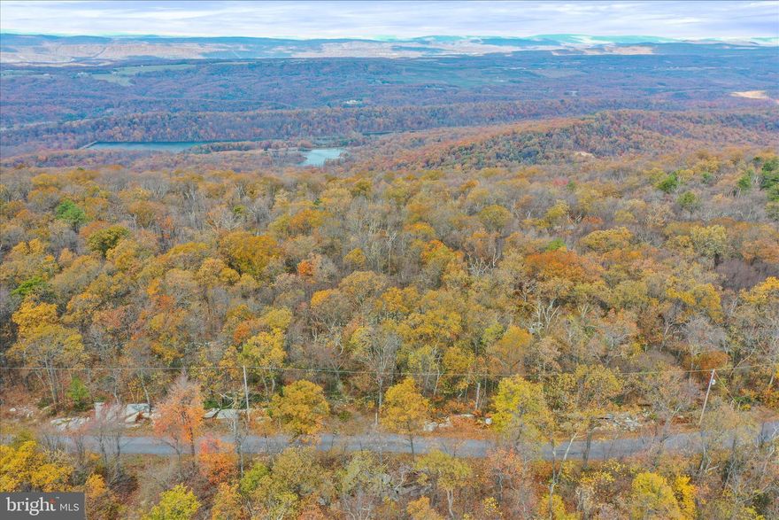 Priced to sell! This wooded, Half Acre, unimproved lot at the top of the mountain in the amenities-filled Shawneeland community offers privacy and views once developed. Perfect for a weekend home, vacation getaway, or full-time residence! Roads and common areas are maintained (including plowing!) by the Shawneeland Sanitary District, with fees of only $190/ yr! Shawneeland features Lake Cherokee, a fishing and boating (non-motor) lake with a recreational beach area. With common areas such as a playground, baseball field, hiking trails and additional lakes, there are plenty of activities for homeowners year-round! Buyer to verify lot lines and due diligence for building.