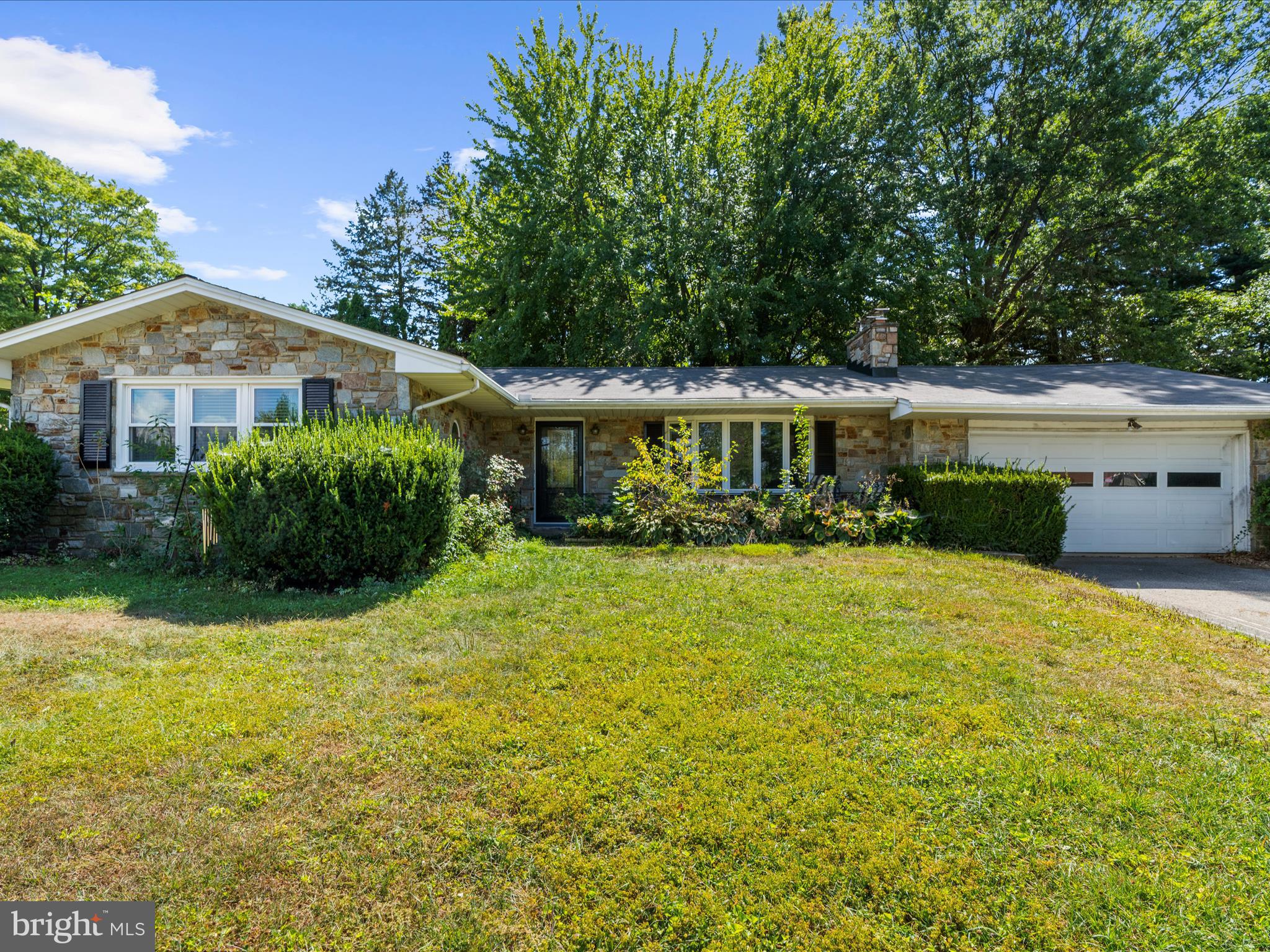Your search stops here! Come tour this beautiful stone siding rancher on a spacious half acre corner lot with 2-car garage! The home features original hardwood floors, bay window, and fireplace in the living room. Updated modern kitchen with two-tone cabinets, lighting, granite countertops, stainless appliances with built-in microwave, backsplash, picture window & a separate dry bar with additional cabinet and table space that is perfect for hosting gatherings. Primary bedroom with private half bath, plus 2 additional bedrooms & full hall bath with dual sinks. Laundry and a second half bath are also on the main level. The walk-up attic provides plenty of additional storage. Basement with a rec room & 2nd fireplace, large partially finished room that can be used for a pool table, table tennis and game room. The unfinished section is the utility/storage area. Enjoy the lovely backyard with patio, hot tub & shed. Additional updates include newer windows & sliding glass door. Located near shops and restaurants. This home will not last long, so be sure to schedule your showing before it's too late.