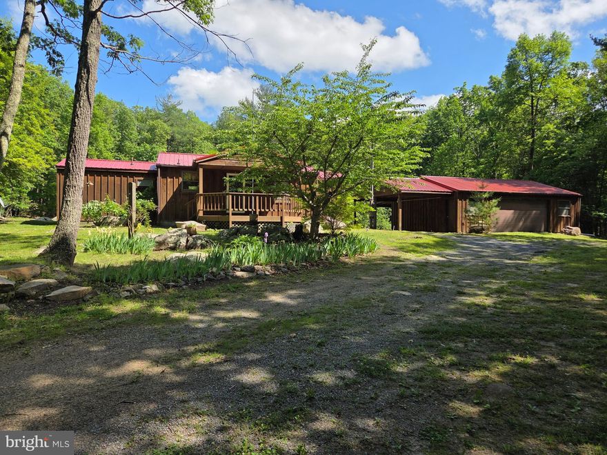 PRICE REDUCED!!    PARK-LIKE SETTING!!!  Once a singlewide manufactured home converted to a very cozy getaway cabin with wood laminate flooring and a spacious living room area.  Front porch deck overlooks beautiful natural landscaping and circular driveway leading up to the cabin. Gorgeous open rear yard with sporadic placed trees and  "natural rock outcroppings"...fire pit too for relaxing evenings!  Wait there's more... a detached 2 car garage  with attached carport!  Just five miles outside of Capon Bridge...Secure your weekend getaway!  Motivated seller - Priced to sell!