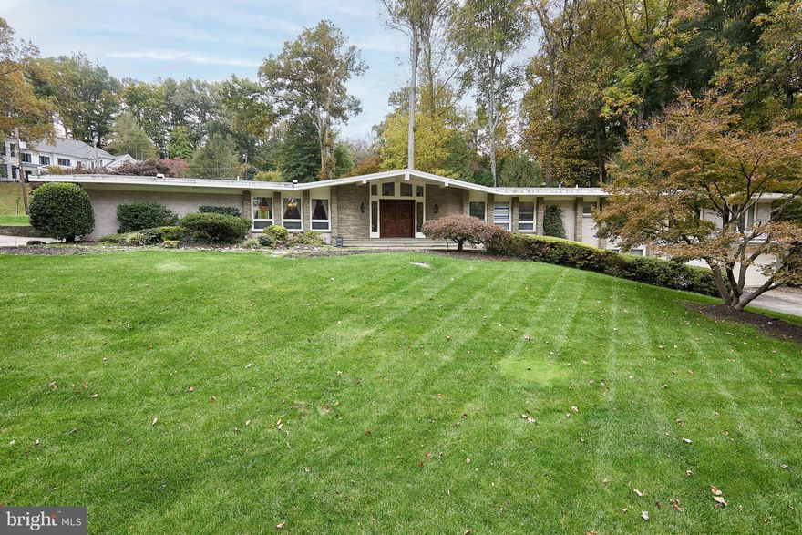 Welcome to this extraordinary well maintained Mid-Century Modern situated in the highly sought-after neighborhood of Bannockburn Estates in the vibrant Bethesda. This expansive architectural masterpiece boasts over 7300 square feet of living space and is nestled on a sprawling lot spanning over .65 acres, providing a serene retreat of privacy and tranquility. Upon entering this Hollywood Regency, you will be captivated by the impressive front entry foyer, boasting soaring ceilings and adorned with elegant double wood doors and an alluring chandelier, setting the tone for the rest of the home. The grand scale living room awaits beyond, featuring cathedral ceilings with exposed beams, elegant wood  burning fireplace, timeless crystal chandelier, oversized windows with verdant views, exposing an abundant of natural light, and a wet bar paying homage to the "Mad Men" era with a built-in turntable and tape recorder!  The main level features five bedrooms, four full bathrooms and one half bathroom including the expanded primary ensuite with dual vanities, providing an amazing retreat for relaxation.  The open layout seamlessly connects the living spaces for friends and family gatherings. The eat-in kitchen is generous in size with granite  counters and ready for the buyer’s personal touches with plenty of room to add an island and connect the adjacent spacious family room for today’s living. The dining room provides a picturesque setting for enjoying meals with loved ones and grand scale dining for formal entertaining. The interior of this home is filled with desirable features too numerous to mention! The attention to detail and craftsmanship is evident throughout, making this residence like no other. The lower level offers two generous bedrooms, one full bathroom and one-half bathroom with direct access to the oversized two car garage, abundant storage and a caretaker’s ensuite. Step outside and discover the beauty of the expansive lot surrounding this home. The outdoor space is a true oasis, featuring a patio area with a gas line connecting to the BBQ that conveys, where you can unwind and create a picturesque backdrop, offering a serene escape from the hustle and bustle of everyday life and ample room for family entertaining. The paved driveways have an abundance of parking for grand scale entertaining. Additionally, the property is equipped with natural gas three zone HVAC and hot water systems, ensuring comfort and efficiency throughout the year.  Located in the vibrant community of Bannockburn Estates, the residents enjoy neighborhood festivals and a walking club. The estate is ideally situated near shopping centers including a Whole Foods market, Glen Echo Park, Sumner Place and quick access to Downtown Bethesda, DC and Virginia. Top Rated Schools include Bannockburn Elementary, Pyle Middle School and Whitman High School, Landon and Holton-Arms Private Schools. Enjoy easy access to shopping, dining, and entertainment options, while still being able to retreat to your own private oasis. Don't miss the opportunity to own this exceptional Mid-Century estate. Schedule a showing today and experience the timeless elegance and luxury that awaits you.