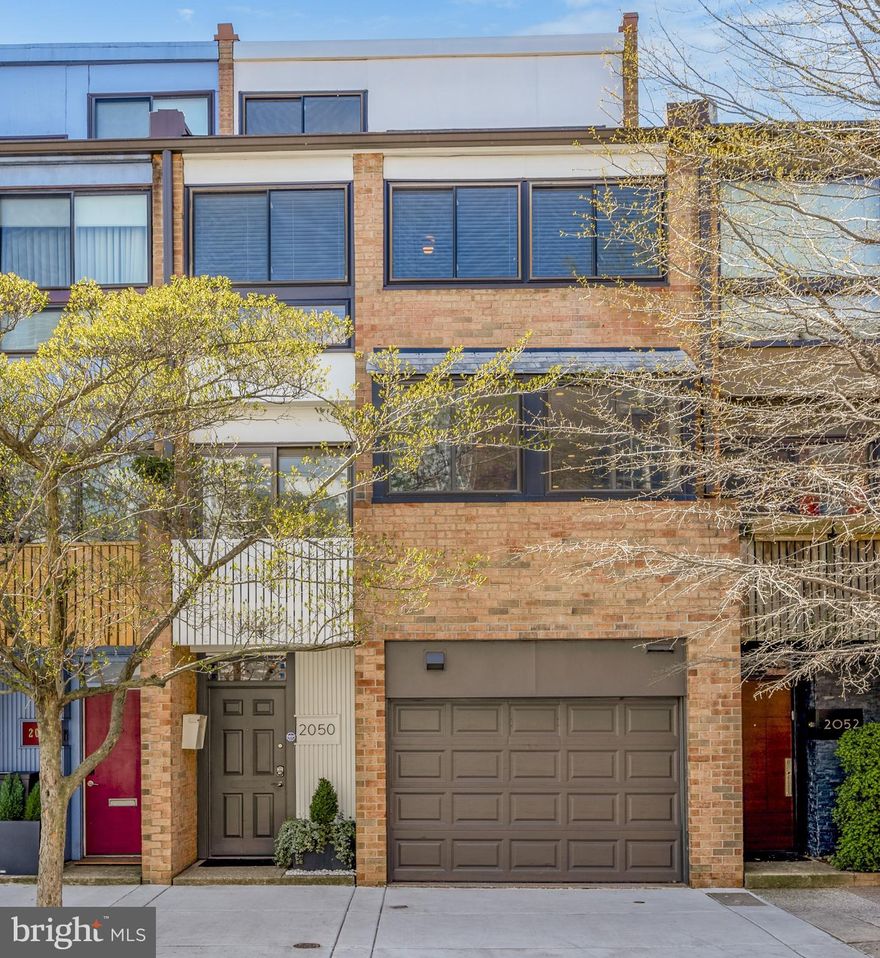 Welcome to 2050 Lombard Street! This modern California-style townhome with a 1-car garage and ample outdoor space features an abundance of light and has been meticulously updated and maintained throughout. Located just blocks from Rittenhouse Square and other center city attractions, the walkability and convenience here is truly remarkable. The entry level with tiled floor and recessed lighting includes a coat closet and interior access to the oversized 1-car garage. As you step down into the lower level den area, you'll notice the beautifully wallpapered powder room and the home office / den with ceramic tiled floor, built-in shelving, recessed lighting, closet storage, mechanical room, and access to the professionally-landscaped, expansive and idyllic garden with slate patio, that backs to a secured alleyway. The living level of the home features hardwood floors, an exterior staircase access descending to the patio and garden, a wood-burning stove, ample light from the south-facing wall of windows, and soaring two-story ceilings with a dramatic custom chandelier. The kitchen and dining level includes the stunning gourmet chef's kitchen which was designed by a Bay Area architect and includes an eat-in walnut butcher block island, a tiled backsplash, Thermador and Sub-Zero appliances, a beverage refrigerator, a full dining area overlooking the living space, a breakfast area with floating shelves, AND access to an outdoor balcony. One level up is a mezzanine sitting area with automated window shades overlooking the living area and access to the recently renovated primary suite. The primary bedroom features hardwood floors, recently re-designed closets, a vaulted ceiling with fan, and the beautifully updated en-suite bathroom which includes a double vanity, a frameless glass shower, an abundance of storage, and custom tile-work throughout. The second bedroom on the next level up also features vaulted ceilings, hardwood floors, a double closet and a ceiling fan. The hall bathroom is updated with a modern vanity, tiled floor, a shower/tub combination with subway tile surround, and access to a full laundry closet. Included on the upper level is an additional private bedroom with vaulted ceiling and a desk nook right outside of the doorway. Other notable features of the home include: a garden irrigation system, new window treatments, and many smart home features, including a state-of-the-art security system. Located within the Greenfield School catchment and within walking distance to Fitler Square, downtown shopping, top restaurants, transportation, theaters, parks, UPenn, CHOP, 30th Street Station and so much more, this gorgeous home is an absolute must-see!
