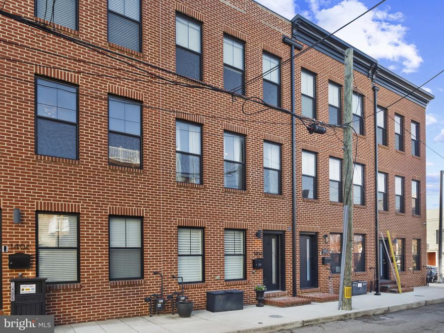 Welcome to 1404 Olive Street at Hanover Crossing in Federal Hill! This 16-foot-wide luxury modern townhome is just 4 years old. Originally the model home for the development, it boasts extra features with four finished levels, 4 bedrooms, 4 full baths, totaling 2,400 sq ft, and a 1-car garage. As you enter, you'll notice the quality craftsmanship, with extensive tile and hardwood floors throughout, tall ceilings, an open floor plan, and beautiful finishes. The main level includes a bedroom and full bath. Heading upstairs, you're greeted by a gourmet kitchen with a large island featuring quartz waterfall countertops, 42" cabinets, and professional appliances. There's a small grill deck right off the kitchen. You'll love the open floor plan, offering ample space for your dining room table and a welcoming living room with a fireplace. The third floor features the primary bedroom with an ensuite spa bath and a third bedroom with a bath. On the fourth level, there's another bedroom with a bath, as well as a cozy loft den with a wet bar and beverage fridge. Relax on your roof deck with amazing views of the city, M&T Stadium, and enjoy multiple firework shows on the 4th of July. Hanover Crossing offers exceptional walkability to downtown, the waterfront, bike trails, restaurants, and entertainment, with easy access to all major roads and highways.