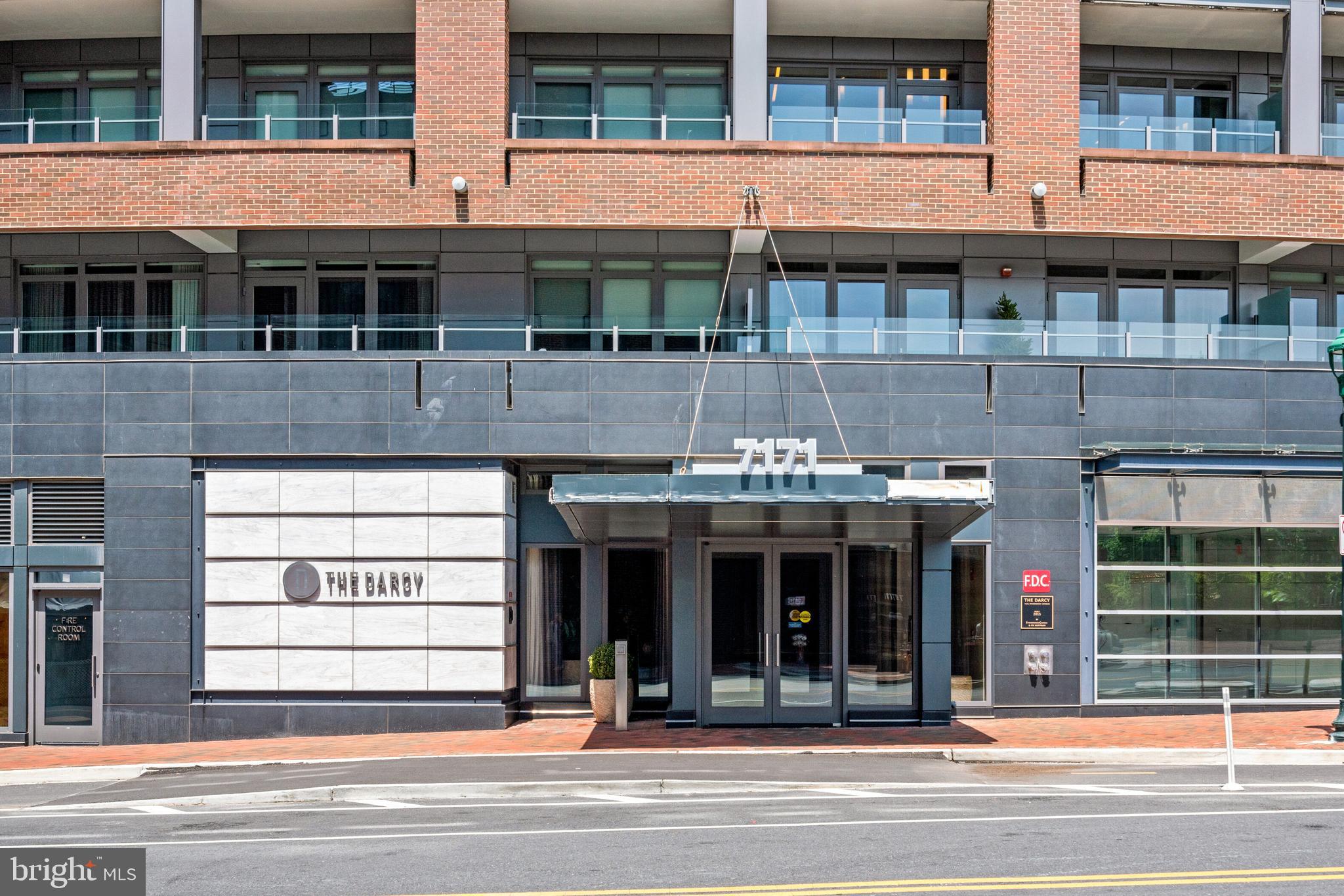 Situated in the heart of downtown Bethesda, this exquisite three bedroom, two and a half bath condo is located in the Darcy, a pet-friendly boutique building with countless amenities. Located on the west-facing side of Woodmont Avenue, this unit highlights stunning sunsets and views into downtown Bethesda. The open floor plan is flooded with natural light and boasts an inviting foyer that opens into a gorgeous living room with floor-to-ceiling windows, elaborate track lighting, a balcony, as well as, the formal dining area. The gourmet eat-in kitchen features high-end stainless steel appliances (including Bosch wall oven, convection microwave, range and hood, and dishwasher, uline wine fridge, Thermador fridge/ freezer), center island with seating, granite countertops, glass subway tiles, pantry cabinet, built in desk, space for a breakfast table, and access to an additional balcony with weather proof flooring . This unit has three bedrooms and two full bathrooms including the primary suite with dual walk-in closets by California Closet, and a spa-like ensuite bath complete with a double vanity, walk-in shower, and separate soaking tub. Completing this unit is a powder bathroom and a separate laundry room with ample storage, a sink, and a full size washer and dryer. This unit also conveys two garage parking spots and an additional storage unit.The Darcy is situated in a wonderful urban environment, just steps away from the Metro and downtown Bethesda, with shops, restaurants, grocery stores, and biking/walking trails, plus close proximity to downtown DC and Friendship Heights. Building amenities include an elegant lobby that was recently renovated and designed by Barry Dixon with 24-hour concierge, a club room with a fireplace, balcony, and catering kitchen, a business center, a private fitness center with a separate yoga studio, and two guest hospitality suites for residents.