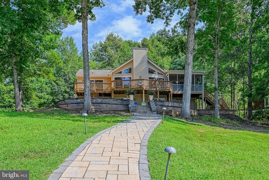 Experience lakefront living at its finest in this fully furnished waterfront retreat located on the public side of Lake Anna, in the sought-after Wyndemere community. Perfectly positioned on a 1-acre cul-de-sac lot with a prime mid-lake location, this home offers gorgeous panoramic views, deep water, and 240 feet of rip-rapped shoreline, making it an exceptional setting for year-round enjoyment.
Boasting 3,486 finished square feet, the home features 5 bedrooms and 3 full baths with an open floor plan and split bedroom design ideal for both entertaining and everyday living. The family room is a showstopper with vaulted ceilings, wood beam accents, a stunning stone wood-burning fireplace, and sliding doors that open to an expansive deck overlooking the water. The spacious kitchen is equipped with maple cabinetry and stainless steel appliances, seamlessly flowing into the main living areas.
The main-level ensuite offers a walk-in closet and tile shower, while two additional bedrooms and a full bath complete the main level. The finished walkout basement provides even more living space with a family/rec room, two lakeside bedrooms, a full bath, and a storage room/owner’s closet—perfect for hosting guests or extended stays.
Outdoor living is unmatched with a screened-in porch, concrete patio, extensive hardscaping, outdoor shower, and fire pit, all designed to maximize the lake lifestyle. Enjoy deep water (12–14 feet at the end of the dock) and a covered boathouse featuring maintenance-free decking, an electric boat lift, storage room, and sun deck. Additional features include a whole-house water filtration system, oversized one-car garage, and a paved circular driveway.
The Wyndemere community, located in Spotsylvania County, VA, is home to 244 lot owners and offers outstanding amenities including three marinas with a private boat launch, boat slips, waterfront picnic areas, and tennis, pickleball, and basketball courts. Enjoy easy water access to restaurants and marinas and close proximity to the Lake Anna Food Lion, ABC store, dining, tap house, winery, cidery, brewery, yacht club, state park, MooThru Ice Cream, and mini golf.
Conveniently located 1.5 hours from Northern Virginia and 1 hour from Richmond, this lake oasis is ideal for entertaining or creating lasting family memories. Comcast Xfinity internet is available, making this an excellent full-time residence or vacation getaway.
This exceptional Lake Anna property offers the perfect blend of comfort, location, and lifestyle—move-in ready and ready to enjoy from day one.