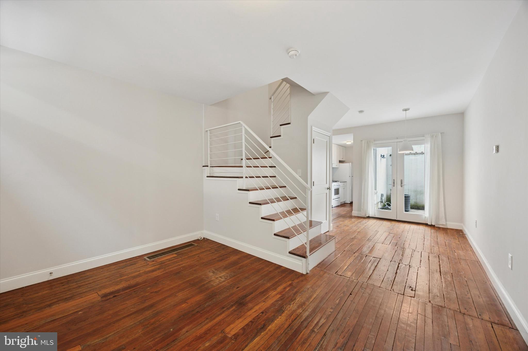 This sweet, classic Philadelphia rowhome was totally renovated with Wagner Urban Development’s hallmark top-notch workmanship and materials, hand-picked finishes, and smart use of space that make the square footage feel and function like a significantly larger house. Distinct living and dining spaces with original wide-plank pine floors that run throughout are defined by a center staircase, yet an open and airy feeling remains thanks to the Jeld Wen double doors to the rear patio that flood the entire floor with light. The kitchen makes super-efficient use of its square footage with plenty of storage and prep space via white Shaker-style cabinets and open shelving paired with white Whirlpool appliances including a five-burner range, subway tile backsplash and an undermount sink set in cement-look counters. Upstairs the large primary bedroom has two windows and a large closet, while the rear bedroom has a double window and its own good-sized closet. Pocket doors allow for great flow from room to room; the stylish bathroom has a large skylight, handsome floating storage vanity with sconce lighting, and a great combination of blue ceramic floor tile and gray subway wall tile with full surround in the extra-large walk-in shower. There’s a hall linen closet on this floor; laundry and storage are in the basement; and breezeway access from the street to the rear patio creates easy in/out access for bikes and trash day. This quiet little block is in a great location convenient to the Italian Market, South St, Broad St and Washington Ave, and around the corner from Hawthorne Park and Ridgeway Rec public pool.