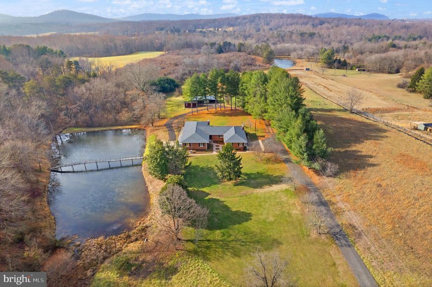 PRICE IMPROVEMENT!  AN EXTRAORDINARY ESTATE sitting on nearly 12 acres in highly sought-after Rappahannock County, boasting spectacular sunrise, sunset, and mountain views. A HOME PLUS AN INVESTMENT opportunity perfectly suited for equestrian pursuits, mini-farm aspirations, or simply serene country living. HIGH-SPEED INTERNET (Xfinity, Verizon) is ready to connect. NO HOA. LOCATED NEAR the Rappahannock and Culpeper county lines, enjoy easy access—just 15 minutes—to Warrenton's amenities, Route 29/Lee Hwy, and the rapid development at Clevengers Corner. 
THIS UNIQUE ESTATE offers a home with over 6,300 total sq ft. Call it a one-unit home with 7BR/4FULL BA or a two-unit home with 5BR/3FULL BA and 2BR/1FULL BA, making it an unparalleled added investment for your agricultural ventures, multi-generational living, or Airbnb! 
THE HOME IS A CHERISHED, custom-built brick home since sellers built it. THE RENOVATED LOWER LEVEL offers complete independence as a true 2nd home, with its own entrance, own parking, a full kitchen (2 stoves!), 2 add'l BRs, 1 full BA, a 2nd laundry, and a colossal bonus rm to add more rooms – perfect for extended family, guests, or even rental income!   A GRAND EUROPEAN-FEEL OPEN-PLAN HAVEN on the main level, featuring original solid oak hardwood floors, exquisite Italian tile, a massive formal living room with a hand-laid stone fireplace, a large eat-in kitchen with custom oak cabinetry, a cozy family room with a 2nd fireplace, 5 spacious BRs, and 3 full BAs. OUTSIDE ARE 2 LARGE PATIOS. A SPACIOUS BARN/GAR/SHED provides ample room for hobbies or storage. ESCAPE TO THE TRANQUILITY of the countryside without sacrificing connection, and have convenient access to Warrenton, Culpeper, Little Washington (home to the renowned Inn at Little Washington), Sperryville, world-class wineries, breweries, distilleries, golf courses, Shenandoah National Park, and just 90 minutes to DC.  Major items incl roof (2019), water heater (2022), Kohler Pwr Sys Backup Generator (2023), Lower LVL washer/dryer (2024), septic pumped (2023), and underground heating oil tank inspected and clear (2025).