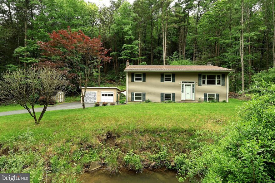 A rural 'home sweet home' awaits you in this vintage split entry ready for your vision and updates! This well loved 3 bed, 1 bath home features a beautiful 1.3 acre lot with quintessential Central PA hills and wooded areas. Up from the welcoming foyer with transoms and a cute cubby, the main living area greets you with a charming living room with hardwood floors and big windows perfect for catching up with neighbors or hosting book club. A sweet country kitchen is the perfect place to bake cookies or share stories around the table. With wood cabinets and a well appointed layout, this space would be a breeze to update! The open concept dining area provides space for hosting your nearest and dearest for everything from Sunday supper to Thanksgiving feasts! Three nicely sized bedrooms with hardwood floors can be found back the hallway and share a full bath with tub/shower combo,  retro teal accents, and a linen closet. The hallway also has a closet with apartment size washer/dryer hookups available (full size hookups are also available in the unfinished portion of the lower level) and pull down stairs to the attic. If you're needing a little extra space for rambunctious game nights, the lower level features a family rec room with oil stove perfect for long winter nights. You'll also appreciate the new well pump and whole house water treatment system with UV light. Ready for your TLC, the back deck has a roof and is a great spot for an afternoon thunderstorm viewing or sunny day iced tea sipping once restored! You'll love exploring the beautiful lot with hills and wooded areas as well as space for gardens. The one car integral garage features a workshop and storage area and more storage and hobby space can be found in the detached 2 car garage with dirt floor and garden shed. A twenty minute drive from campus, this home can provide you all the joys of country living with still easy access to town and shopping! Come check it out today!