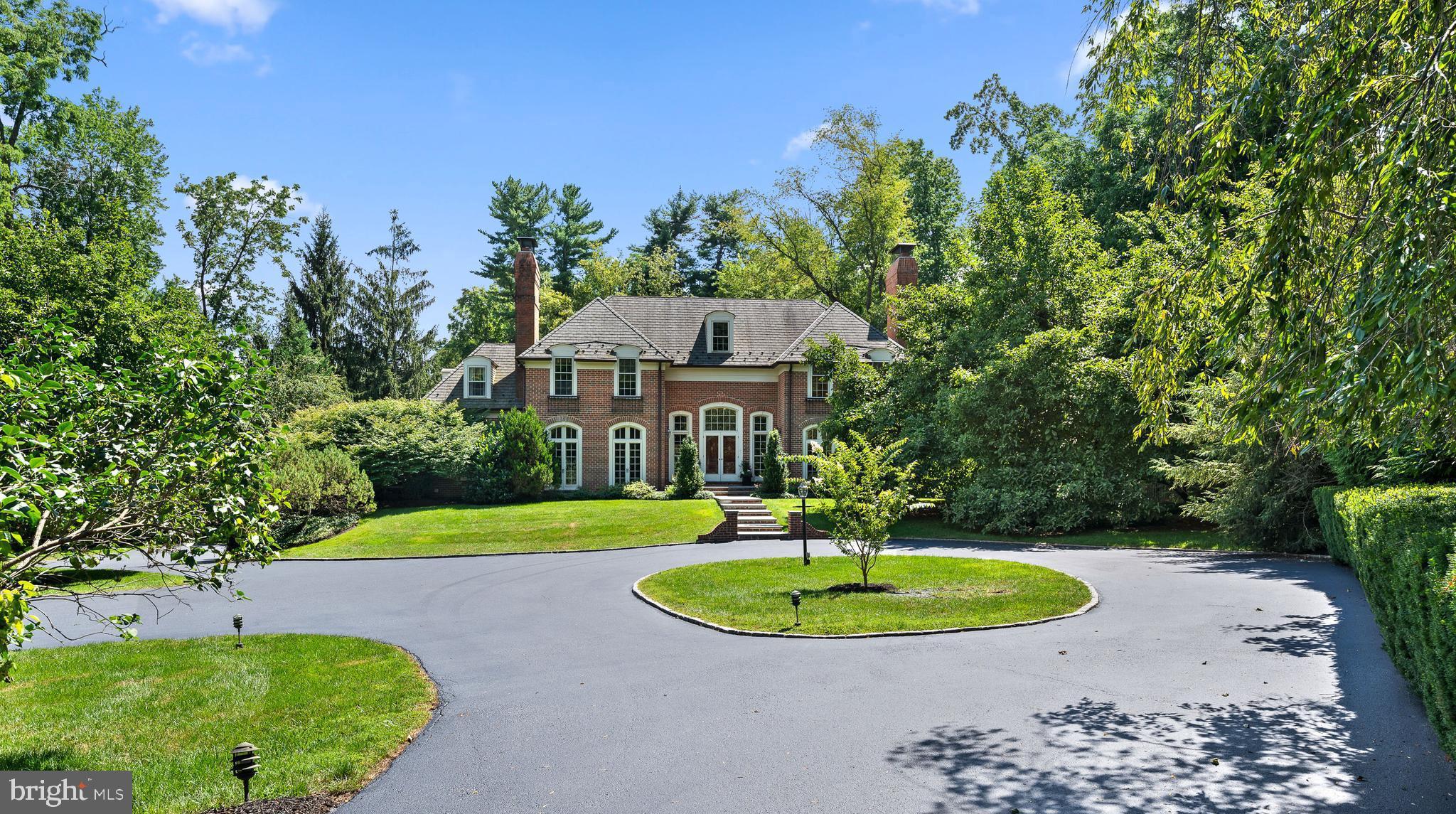 This stately brick Georgian Colonial is perfectly set on a quiet cul-de-sac overlooking the fields of historic Harriton House, in one of Lower Merion's most coveted Northside Bryn Mawr neighborhoods. Truly a one of a kind property offering privacy and majestic grounds, a magnificent pool, an all brick exterior and a stunning interior. A hedge lined circular driveway invites you to be impressed by the private & beautifully manicured grounds. A flagstone walkway leads you to the dramatic entry with wide slate steps, and double door entry. Step into the romantic two story foyer complete with gleaming hardwoods, large windows streaming in sunlight, arched entryways and a dramatic curved staircase. This estate's open floor plan and sunlit spaces make it an entertainer's dream. The inviting living room with multiple french doors to welcome the outside in, is the perfect place to sit fireside and enjoy a book in front of the Marble surround gas fireplace. The dining room can accommodate a large dinner party perfect for holiday celebrations, and features french doors, and a wood burning fireplace. A chef's kitchen, designed by Joanne Hudson, overlooks the stunning grounds, this kitchen has been thoughtfully laid out and offers every amenity a serious cook desires, Thermador and Sub Zero appliances, two dishwashers, two ovens, dual sinks, an abundance of light custom cabinetry and a large island. The sunlit breakfast room opens onto the wrap-around deck offering serene views and a delightful place to sit and sip your morning coffee as well as a lovely extension for casual indoor/outdoor entertaining. The kitchen is open to a cozy family room with fabulous hand carved mahogany built-ins and a magnificent sun room with 3 walls of windows offering unobstructed views of the stunning yard and the idyllic Harriton House grounds beyond. The sunroom offers french doors opening to an outdoor patio. A private home office with built-in cabinetry and shelving, and a stunning renovated powder room with designer tile accent wall are tucked in off of the foyer. An additional powder room and mud room with ample closet space complete this level. Climb the sweeping staircase and enter the double doors to the Primary suite, and you are welcomed to a space reminiscent of a fine luxury hotel suite. The large bedroom has glorious vaulted ceilings, a gas fireplace with limestone mantel and sitting area. The bathroom is truly luxurious with separate vanity areas each with their own toilet room, joined by an enormous frameless glass shower complete with rain shower head & handhelds, bench & mosaic tile. A soaking tub and custom mahogany vanity with onyx top are just a few of the highlights of this spectacular bath! The oversized custom outfitted dressing room completes this amazing space. Down the Hall is an en suite bedroom with two custom outfitted closets and an updated designer tile bath with shower/tub combo. The third bedroom has a walk-in closet and its own sink and vanity and shares a recently renovated bath complete with linen tile, frameless glass shower door and a vanity with marble top, with the 4th bedroom. There is a third floor walk up attic that is perfect for finishing if additional space is needed, and is great for storage as is. The walkout daylit lower level has a dressing room & full bath, perfect for the pool! A wet bar and two double glass doors opening to the bluestone patio & pool area make this a perfect place to entertain while using the pool and for caterers to set up for outdoor affairs. There is also plenty of storage, a wine closet and a cedar closet! An oversized three car garage with additional storage space completes this home. Overlooking the Harriton house grounds where you occasionally catch a glimpse of their horse making it feel like the countryside, while living in the heart of Lower Merion School District. Close to shopping restaurants, schools, highways, & center city Philadelphia.