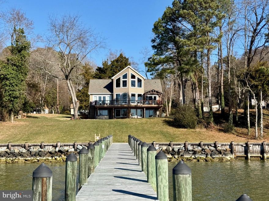 Coastal living at its finest on the Patuxent River, with panoramic waterfront  views from all three levels! 

This stunning home features an open floor plan and a dramatic two-story great room highlighted by a wall of replacement picture windows and a wood stove overlooking the river. Over all square footage is 3840.  Hardwood flooring spans two levels. The kitchen was fully remodeled in 2015 with custom Sapele mahogany cabinetry, granite countertops, stainless steel appliances, a dry bar and window seat with view. The main level includes the master bedroom & full bath, while the upper level offers a large bedroom and full bath. The remodeled lower level features LVP flooring, a third bedroom, full bath, media/game room with custom built-in bar, large storage room with workshop space, large laundry with cherry cabinetry, granite countertops, and space to exercise with a view. Two large attic storage areas add convenience.  

House has a 350-amp electric upgrade with EV charger. A two-car garage includes a full-size car lift to accommodate a third vehicle. Enjoy outdoor living on the expansive 48' deck offering over 900 sq ft of entertaining space, plus a riverside patio. Recent upgrades include a new roof, new BAT septic system, and most windows replaced. The lot size is inclusive of a second non-contiguous parcel where the recently replaced septic drain fields are located. Boaters will appreciate the 200' private pier with water, electric & boat lift. View both sunrises and sunsets as you watch ships and oyster boats pass by and enjoy exceptional fishing, white-sand swimming, and boating right from your backyard.