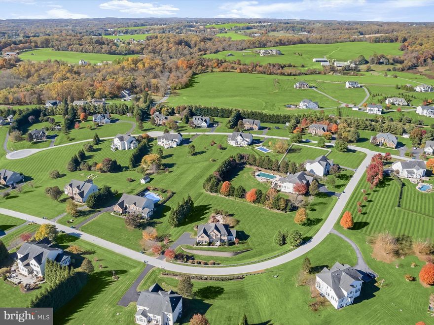 Outdoor entertaining is the hallmark of this incredible home nestled in the desirable community of Freedom Hills Farm. Set on a beautifully landscaped 1.06-acre lot, this stunning property boasts multi-level custom patios, creating a serene outdoor oasis perfect for relaxation and gatherings. Inside, meticulous craftsmanship is evident throughout, with hardwood floors, classic moldings, and stately columns adding to its timeless elegance. A grand two-story foyer welcomes you into the home, leading to a formal living room and a dining room adorned with a lit tray ceiling and stately columns. The morning room, featuring gleaming marble floors and built-ins, offers breathtaking views of the picturesque grounds. The eat-in kitchen is a chef’s dream, equipped with sleek stainless steel appliances, granite countertops, WiFi-enabled double wall oven, decorative backsplash, a center island with a breakfast bar, display cabinetry, and a pantry. The space seamlessly flows into the breakfast room, which boasts vaulted ceilings and direct access to the outdoor retreat. The inviting family room is set off the kitchen and showcases soaring two-story vaulted ceilings, a striking stacked-stone fireplace, hardwood floors, and a back staircase leading to the upper level. A private office with custom built-ins, a laundry room, a powder room, and garage access complete the main level. The primary suite is a luxurious retreat, featuring a tray ceiling, two walk-in closets, a sitting room, and a spa-like en-suite bath with separate vanities, a soaking tub, and a glass-enclosed shower. Three additional spacious bedrooms and a full bath complete the upper level. The lower level is designed for entertainment and comfort, offering a game room, media room with a wet bar, fifth bedroom with direct access to the backyard, full bath, and ample storage space. An attached two-car garage provides plenty of storage, while an extended driveway ensures ample parking.