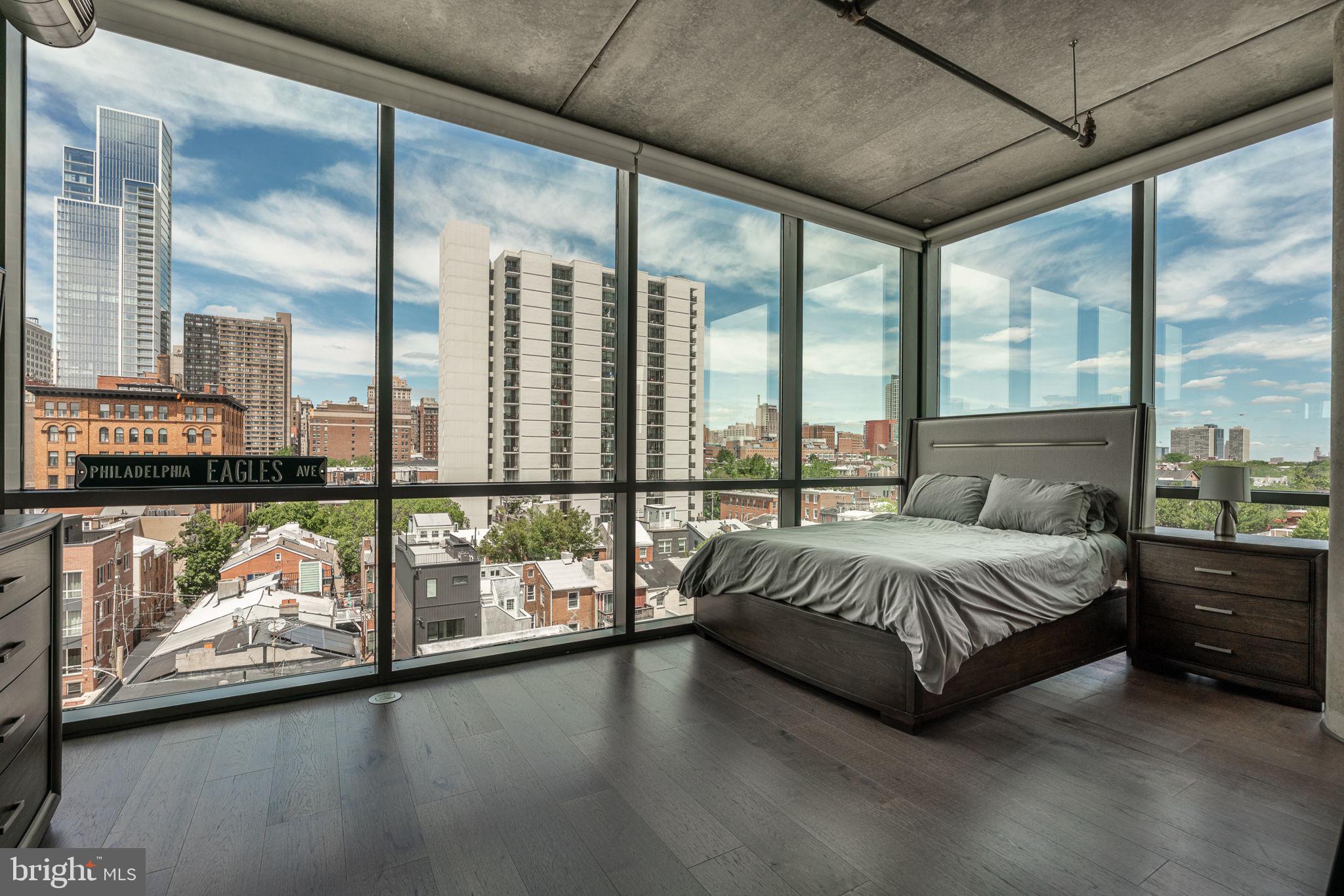 A long awaited penthouse unit has come to market!! Spectacular views of center city! 1352 Lofts - - a 72 Unit contemporary mid rise condominium building at the Broad and South Street intersect. This 5th Floor unit has 1260 square feet over an open floor plan and 9 foot ceilings that flow really well together. Floor to ceiling windows - - incredible natural light with northern and eastern exposure. Private outdoor balcony off the living room. Wood flooring throughout, bold contemporary kitchen cabinetry and granite stone. Recessed lighting fixtures. In unit washer and dryer / Individually controlled central air heating and cooling.
This unit comes with a deeded covered parking spot in the garage! The building offers a 24hr doorman, and a wonderful staff to maintain and serve. Whole foods grocery two blocks away and the abundance of activity on the South Street corridor. This is an exceptional opportunity to own a unique penthouse unit that rarely comes along in the neighborhood.