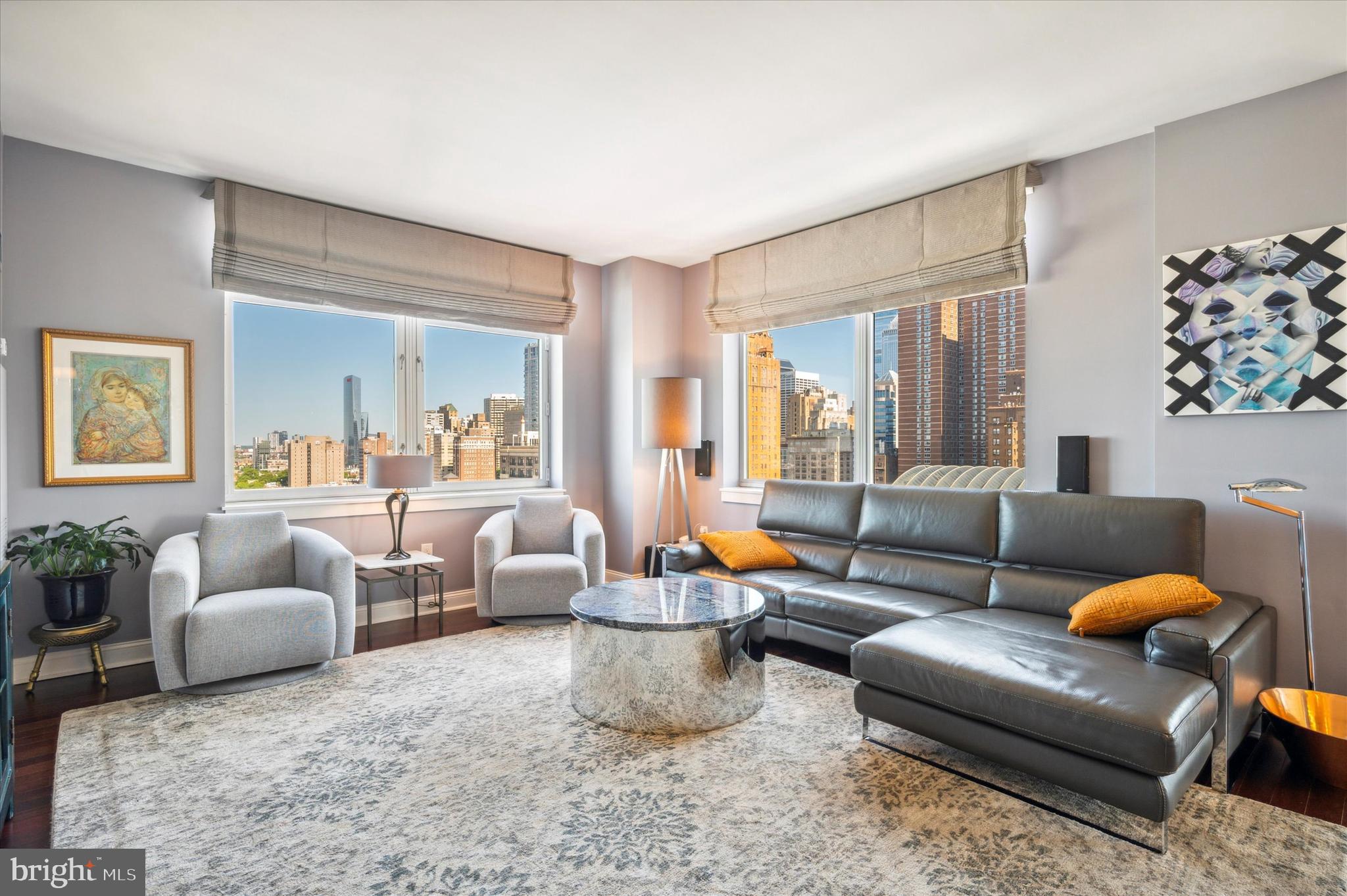 Enjoy unobstructed views of Center City Philadelphia from this luxurious Symphony House condominium. Located in the heart of the city and just steps from theaters, restaurants, historical attractions, shopping, Rittenhouse Square, public transportation, and more. Natural light floods the 3-bedroom, 3-bathroom unit creating a bright and airy atmosphere. Enter into a foyer with beautiful hardwood floors that flow seamlessly throughout the condo. The living room, kitchen, and dining area offer an open concept perfect for entertaining. An updated kitchen is a culinary enthusiast's dream, featuring white Shaker-style cabinets, quartz countertops, glass tile backsplash, a pantry cabinet, stainless steel appliances, a wine cooler, a built-in refrigerator, 5-burner gas cooktop with range hood, and a breakfast bar with pendant lighting and ample seating and for casual dining. Floor-to-ceiling windows in the dining area provide phenomenal views of the city. From the dining area, step outside to a private deck perfect for enjoying your favorite beverage. The primary bedroom boasts a large walk-in closet with custom built-ins, a ceiling fan, black-out shades, and an en-suite with double vanity and an oversized walk-in shower with a frameless glass door. The second bedroom also includes an en-suite bathroom with shower. The third bedroom has been thoughtfully transformed into an in-home office with custom built-ins, perfect for those working remotely. All three bedrooms come equipped with custom California closet built-ins for optimal organization. The third, full bathroom has a tub/shower combination. For added convenience, motorized shades/window coverings are throughout the condo. The Symphony House offers first-class amenities including, 24-hour front desk concierge, an indoor swimming pool, fitness center, library, a meeting room, extra storage, and more. And with two garage parking spots, you'll never have to worry about finding a place to park in the bustling city.