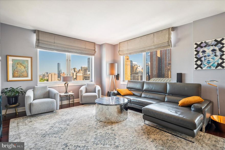 Enjoy unobstructed views of Center City Philadelphia from this luxurious Symphony House condominium.  Located in the heart of the city and just steps from theaters, restaurants, historical attractions, shopping, Rittenhouse Square, public transportation, and more.  Natural light floods the 3-bedroom, 3-bathroom unit creating a bright and airy atmosphere. Enter into a foyer with beautiful hardwood floors that flow seamlessly throughout the condo.  The living room, kitchen, and dining area offer an open concept perfect for entertaining. An updated kitchen is a culinary enthusiast's dream, featuring white Shaker-style cabinets, quartz countertops, glass tile backsplash, a pantry cabinet, stainless steel appliances, a wine cooler,  a built-in refrigerator, 5-burner gas cooktop with range hood, and a breakfast bar with pendant lighting and ample seating and for casual dining. Floor-to-ceiling windows in the dining area provide phenomenal views of the city. From the dining area, step outside to a private deck perfect for enjoying your favorite beverage. The primary bedroom boasts a large walk-in closet with custom built-ins, a ceiling fan, black-out shades, and an en-suite with double vanity and an oversized walk-in shower with a frameless glass door.  The second bedroom also includes an en-suite bathroom with shower. The third bedroom has been thoughtfully transformed into an in-home office with custom built-ins, perfect for those working remotely.  All three bedrooms come equipped with custom California closet built-ins for optimal organization. The third, full bathroom has a tub/shower combination. For added convenience, motorized shades/window coverings are throughout the condo. The Symphony House offers first-class amenities including, 24-hour  front desk concierge, an indoor swimming pool, fitness center, library, a meeting room, extra storage, and more.  And with two garage parking spots, you'll never have to worry about finding a place to park in the bustling city.