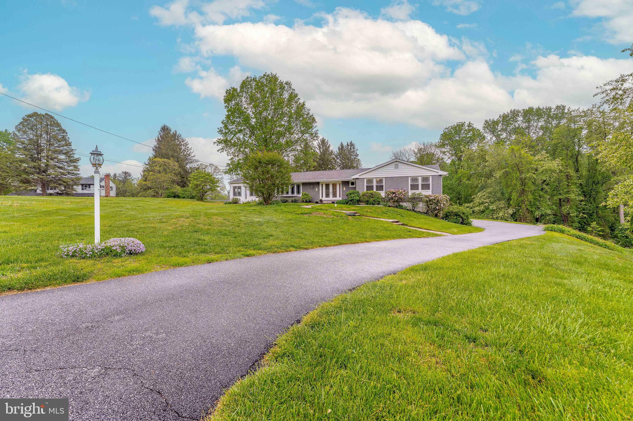 Welcome to 62 Marlborough Lane, a charming 3-bedroom, 2.5-bath ranch-style home nestled on a private cul-de-sac in the sought-after Cambridge Downs neighborhood of Glen Mills. This remarkable home sits on 1.33 acres. With an expansive driveway and an attached 2-car garage with an additional workshop area, this home offers both curb appeal and incredible convenience. Step through the double-door entry into a welcoming foyer with rich hardwood floors. To the left, the spacious living room features hardwood flooring, a cozy wood-burning fireplace and a picturesque bow window, a perfect spot to relax or entertain. Straight ahead, the formal dining room also boasts hardwood floors and provides a tranquil setting for family meals and gatherings. The adjacent family room features carpeting and access to the home's sunroom—a bright and airy space with laminate flooring, vaulted ceilings with skylight, hot tub, as well as direct access to the wood deck and patio with abundant views of the 1.33 acres —ideal for year-round entertaining. The well-appointed kitchen offers ceramic tile flooring, granite countertops, a center island, double sink, breakfast bar with seating, and soft close cabinets. A convenient powder room with tile flooring and sconce lighting completes the central living space. A thoughtfully designed extra-wide hallway leads to the bedroom wing. Two bedrooms feature hardwood floors, spacious closets, ceiling fans with lutron lighting are perfect for children, guests, or a home office. A full bathroom with tile flooring, as well as custom tile surrounding the soaking tub with a marble top vanity accommodates these rooms. The primary suite offers a peaceful retreat with hardwood floors, double windows for natural light, a walk-in closet, and en-suite bathroom. The en-suite includes tile flooring, shower and pedestal sink. Downstairs, the unfinished walk-out basement provides ample storage and 1,700 SF of endless potential for additional living or recreational areas. It includes a laundry area with washer, dryer, and utility sink, and offers direct access to the garage for added convenience. Ideally located just a short walk to Garnet Valley schools, Kids Dream Playground, and Clayton Park Golf Course, this home truly has it all—space, style, and serene location. Don’t miss your opportunity to own this wonderful Glen Mills home—schedule your private tour today!