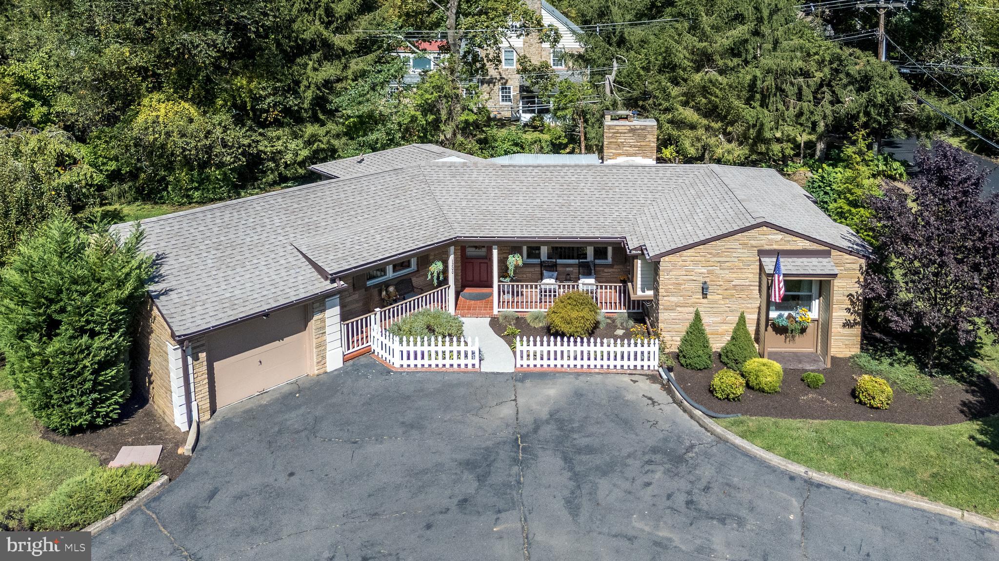 A Mid-Century Modern at its best! Located just a short walk to the charming town and shopping district of Yardley Borough, and in the highly regarded Pennsbury School District, this meticulously maintained ranch home seamlessly blends modern amenities with classic charm. Offering one-floor living in the prestigious West Acres section of Lower Makefield, and nestled on a .40-acre corner lot, this property combines classic character with modern updates in one of Yardley’s most picturesque neighborhoods. Upon arrival, you will find a convenient circular driveway for ease of access that leads you to the charming front porch, a perfect outdoor retreat to sit and enjoy a nice cup of coffee. As you enter the home, get ready to be impressed by the details! You will find a bright open floor plan and an inviting living room with exposed wood beams and decorative fireplace. Large, newer windows allow for tons of natural sunlight and views of the wooded backyard. The living room is open to the cozy dining area, which offers a Butler's pantry with beautiful granite countertops, the perfect place to store all of your entertaining and serving pieces. The kitchen is updated with tile flooring, gorgeous granite countertops, tiled backsplash, cream wood cabinets, stainless steel appliances, and a pocket door for additional kitchen storage space. Off this area is the covered, freshly epoxied, back patio with mounted tv for tranquil nights and outdoor meals. Adjacent to the living room is a home office area which can also double as a separate living area or reading room. Tucked in the corner are wrought iron rails and a curved staircase that leads you down to the finished lower level with built ins, tile flooring, and outside entrance with Bilco door. This level offers an additional family room area, gym space, or could double as a third bedroom. Also down here in its own private room is the nicely finished laundry area that also houses the mechanicals. Back upstairs, the main bedroom is spacious with parquet flooring, deep closet and a well appointed main bathroom. The sunny second bedroom is also spacious with solid wood flooring, ample closet space, and easy access to the retro full hall bathroom. There is alsa a freshly epoxied attached garage, boasting an extra deep length with large storage area in the rear. Notable upgrades to this home include: Roof (2020, transferable warranty), HVAC (2022), Refrigerator & Dishwasher (2024), and Windows (2020). Conveniently located near the train station, major roadways, Princeton, New Hope, Philadelphia, and NYC, plus boutique shopping and fine dining. This lovingly maintained home offers timeless style, modern comfort, and unbeatable convenience.