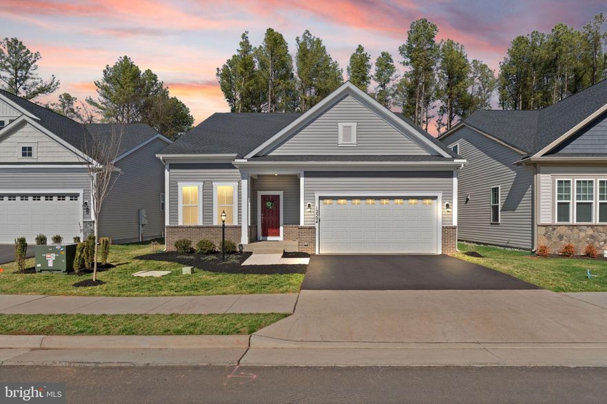 Welcome to this nearly new single-family home in the sought-after 55+ community of The Crest at Linton Hall. Perfectly positioned on a private cul-de-sac lot backing to mature trees, this home offers peaceful surroundings paired with modern, low-maintenance living.  The main level showcases a bright open floor plan featuring a front office ideal for working from home or quiet study. The kitchen is appointed with stainless steel appliances, granite countertops, and a center island, and flows seamlessly into the dining area and spacious family room - perfect for both everyday living and entertaining. Custom blinds throughout and newer luxury vinyl plank flooring across most of the main level add style and durability.  The primary suite offers a private retreat with an attached bath and two walk-in closets. Two additional bedrooms and a separate full bathroom provide comfortable accommodations for guests, hobbies, or additional workspace. The finished basement expands your living space with a large recreation room, full bathroom, and an unfinished area framed for a potential 4th legal bedroom.  There are two additional unfinished rooms that could be perfect for a media room, home gym or just storage!  Step outside to enjoy the stamped concrete patio, installed in July 2025, overlooking the tranquil wooded backdrop.  Additional highlights include an attached 2-car garage with wiring already in place for an electric vehicle charger.  Better than new and move-in ready, this home combines privacy, modern upgrades, and the vibrant lifestyle of this desirable active-adult community, conveniently located near shopping, dining, and major commuter routes.