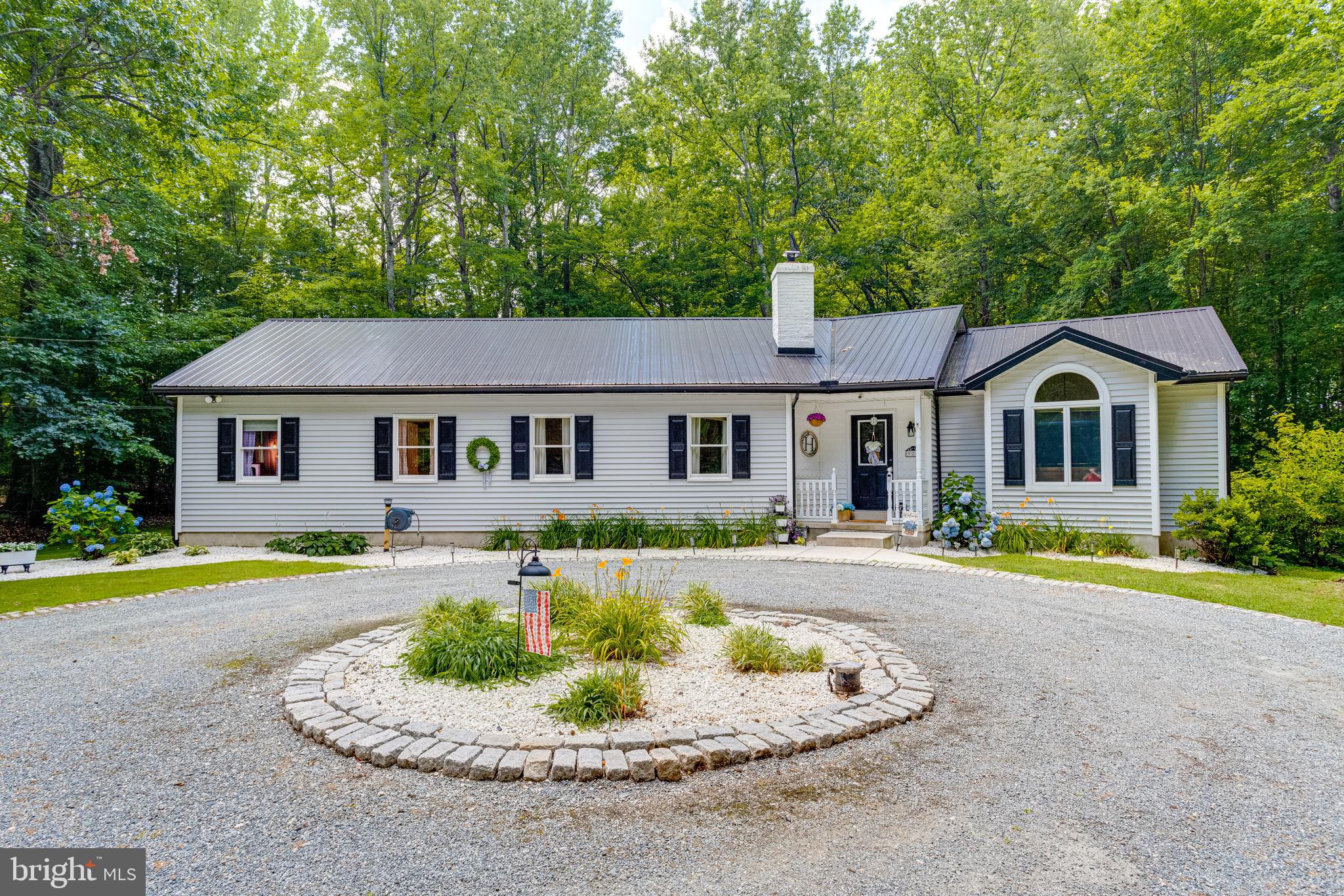 Welcome to 928 Irishtown Road in North East, Maryland! Tucked away on a secluded 1.69-acre wooded lot, this beautifully updated rancher offers the perfect blend of privacy and convenience—just minutes from Main Street’s charming shops, great restaurants, and the inviting small-town atmosphere. Step inside to discover single-level living at its finest. The spacious living room features cathedral ceilings and large windows that fill the home with natural light, creating an open, airy feel throughout. The kitchen is a true standout, boasting stainless steel appliances, granite countertops, and plenty of cabinet and counter space, all flowing seamlessly into a generous dining area ideal for family dinners or entertaining guests.
The home has been thoughtfully updated, including refreshed kitchen and bathrooms, and has seen major improvements like a brand new 50-year metal roof, new gutters, and downspouts for added peace of mind. Outdoors, you’ll love spending time on the large screened-in porch, relaxing on the deck, or unwinding in the hot tub on the beautiful stone patio. When the evenings cool down, gather around the fire pit and enjoy the feeling of camping right in your own backyard. Whether you’re hosting a cookout or simply enjoying the quiet wooded surroundings, this property delivers the tranquil lifestyle you’ve been searching for without sacrificing quick access to town amenities.
This home truly has it all—privacy, modern updates, and an unbeatable location—and it won’t last long. Schedule your private showing today before it’s gone!