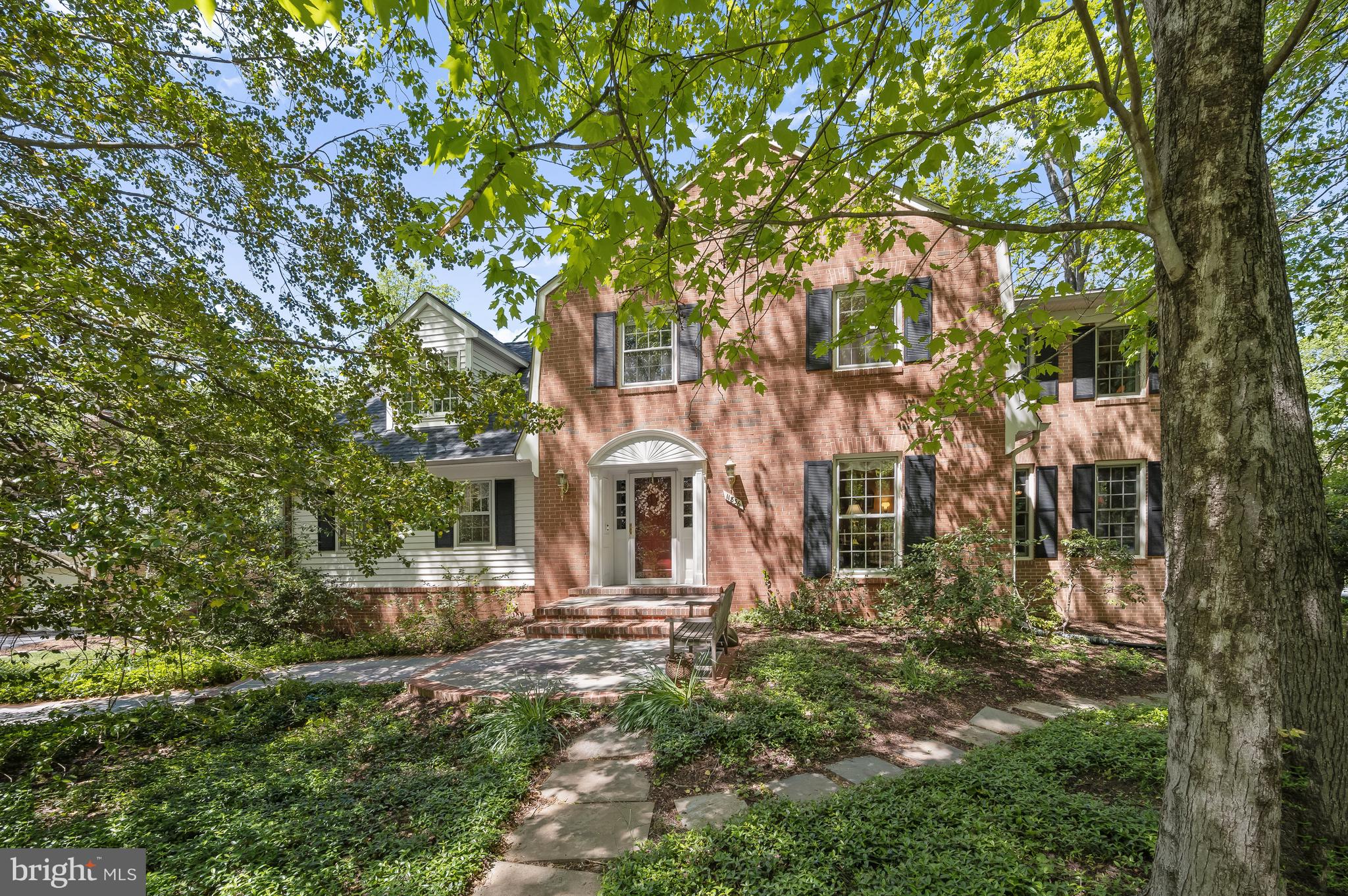 Surrounded by lush greenery on a quiet street in the inviting Country Place Neighborhood, 11836 Hunting Ridge Court is a captivating, classic Colonial, with enviable design details and a major 3 story addition. This special residence boasts 4 Bedrooms, 2 Full Baths and 1 Half Bath across 3 masterfully crafted levels and 4,664 square feet of living space, including Main and Upper Level hardwood flooring and crown molding.
The slate walkway guides residents and guests to the welcoming Front Porch and Entry Foyer, including a lantern pendant light fixture and leads to the Entry Hall, offering a walk-in coat closet and the Main Level Powder Room. The Study boasts stately built-ins; perfect for displaying cherished memories, collections or photographs. The sunny Living Room graciously leads to the banquet-sized Dining Room, showcasing chair railings, a bay window, a chandelier with a ceiling medallion and French doors leading to the Rear Grilling Deck, with stairs to the Lower Level Patio; host intimate and large dinner parties alike in this elegant room. The expansive, island Kitchen includes custom cabinetry, high-end stainless steel appliances, a wine refrigerator, an appliance garage and a desk/work station; a dream come true for any at home chef! The Breakfast Area boasts a lighted ceiling fan and windows overlooking the Rear Yard. The cozy Family Room, open to the kitchen, offers a wood-burning fireplace and a glass sliding door to the Screened Porch. The stunning and spacious Screened Porch boasts a cathedral ceiling, and gorgeous views of the Rear Yard and parkland beyond. The Main Level’s offerings are complete with a large Laundry Room, including a washer and dryer, cabinets, a utility sink and 2 windows.
Ascending to the Upper Level, double doors welcome one to the gracious, expanded Primary Suite with a generous Sitting Room, complete with access to a walk-in closet, 4 additional closets and 2 windows overlooking the rear yard. The Primary Bedroom follows, boasting both front and rear windows. The ensuite, Primary Bath is accessed through the Sitting Room and includes tile flooring, a dual vanity, a corner soaking tub, a stall shower and a view of trees; unwind and relax in this spa-like oasis. The spacious Second Bedroom offers 2 front dormer windows with a window seat, 2 side windows, a large walk-in closet, eave storage and a ceiling fan. The Upper Level’s offerings are complete with 2 additional Bedrooms and a Full Hall Bath, including a vanity, a tub shower with tile surround and tile flooring.
Descending the carpeted stairs to the Walk-out Lower Level, the sizable Recreation Room awaits, showcasing a sliding glass door to the Rear Patio. Additionally, the left of the L-shaped room has a full window and closet, offering fantastic potential to create a Fifth Bedroom. An entry to the attached, 2-Car Garage, the unfinished Storage/Utility Room, and the adjacent unfinished Workroom (also a potential bonus room), including cabinets and Rear Yard access, complete the Lower Level’s offerings.
Whether it is the Screened Porch with gorgeous views, the Main Level Grilling Deck or the brick paver patio with stacked stone wall, the Rear Yard has endless space for entertainment and play!
In close proximity to parkland and nature trails along the Watts Branch stream, Gregerscroft Neighborhood Park, Watts Branch Park, Country Glen Swim and Tennis Club, Wayside Elementary, Cabin John Village and Potomac Village, 11836 Hunting Ridge Court is a truly special residence to call home.