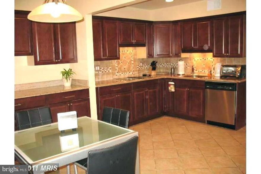 2,640 sq ft total area spacious TH with a bunch of newer updates/replacements: kitchen w/SS appliances and granite countertop, bathrooms, HVAC, windows, deck, hardwood floors on main and upper levels. Huge kitchen w/table space.Roomy foyer.Built-in furniture. Finished bright recreation room in basement with full walkout & bathroom. Convenient location close to I-695 & I-83. Summit Park El. school