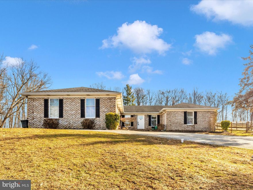 Bring the horses! Welcome to this stunning all brick custom rancher situated on an elevated lot of just under 4 acres with AMAZING views! Owners have updated the entire home  and all systems over the last few years. Featuring 4 bedrooms, 2.5 bathrooms, and an oversized laundry room with dog washing area! The circle driveway and a pass through garage add to the convenience and functionality of this well thought out home. Inside you will find hardwood floors throughout, fresh neutral paint, updated kitchen and bathrooms, an abundance of natural light, and more! Finished lower level features room to entertain and a wet bar! Owners have utilized the entire property for animals. Featuring a converted carport off of the detached garage with 2 rubber matted horse stalls with fans with paddock area. Detached garage also features 220A electric, and a plug in for your RV! Property is fully fenced and features 2 additional pastures out front. The chicken coop even has electric and exhaust fans. Entertain on the large deck and cool off in the above ground pool! The beautiful flourishing landscaping (in-season), a fruit bearing tree, tree lined driveway, and Baugher's Orchard directly behind you add to the privacy and serenity this beautiful property has to offer! Come see for yourself! Work from home? No problem!This property has its own dedicated Comcast business "node" (offering commercial grade bandwidth!) Seller has found home of choice and this one is priced to sell!