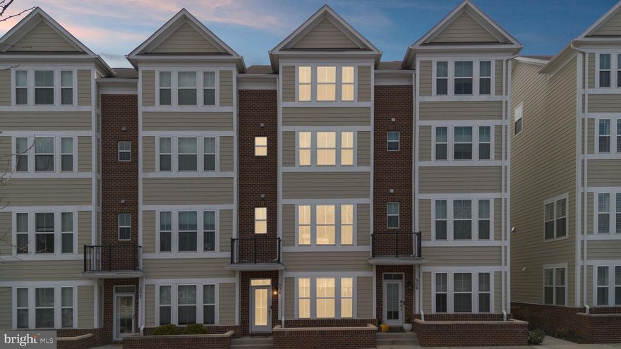 Discover this meticulously maintained, 4-level luxury townhome in the highly sought-after Annapolis Townes at Neal Farm, offered in move-in-ready "model home" condition. The entry level greets you with a versatile flex space—ideal for a home office or gym—complete with a convenient half bath and access to the finished two-car garage. Moving upstairs, the open-concept main level is an open-concept layout, featuring elegant gallery trim moulding, rich hardwood flooring, recessed lighting, and a living room anchored by a cozy gas fireplace with custom built-ins. The gourmet kitchen is a true standout, boasting a massive granite island, Whirlpool stainless steel appliances with a double oven and gas cooking, a stunning backsplash, and a spacious pantry. Bathed in natural light through windows, the dining area flows seamlessly into the heart of the home. Retreat to the third level to find a spacious primary suite featuring a spa-inspired bathroom and a large, custom walk-in closet with floor-to-ceiling storage, as well as a secondary bedroom and full bathroom. The fourth level offers a private sanctuary on its own dedicated HVAC zone, featuring a third bedroom with an ensuite bath and an expansive second living area that leads out to a private rooftop terrace. Parking is a breeze with guest parking located directly in front of the home, a unique advantage of 504 Joseph Johnson Drive. Enjoy easy access to Annapolis Town Center’s Whole Foods, Target, and luxury dining, all with easy commuter access to DC, Baltimore, Ft. Meade, and the USNA.