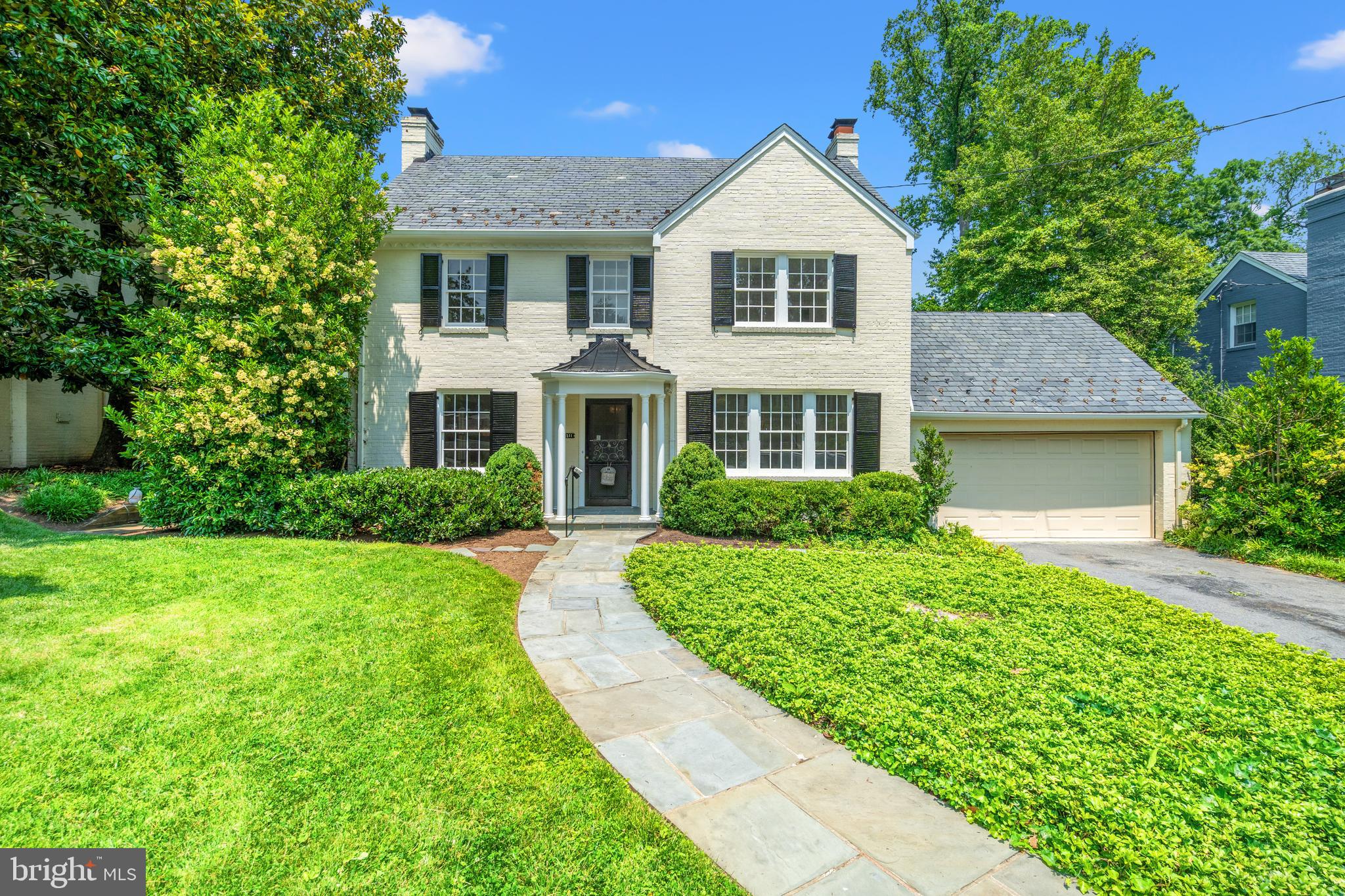 Classic Elegance in the Heart of Rollingwood. This timeless center hall Colonial in coveted Rollingwood seamlessly blends traditional charm with modern updates and generous proportions. Set on an expansive, beautifully landscaped lot with a classic slate roof, the home features spacious rooms, exceptional natural light, freshly painted interiors, and refinished solid hardwood floors.
A gracious foyer opens to the formal dining room on the right, which flows into an updated kitchen equipped with a new LG refrigerator and dishwasher, along with a high-end Thermador gas cooktop and double wall ovens. A rear hall leads to a private office with an adjoining powder room—also accessible directly from the front entry. To the left, the large living room offers recessed lighting, custom built-ins, and a gas fireplace, and opens to a sunroom with a dramatic skylight and serene views of the brick patio and expansive backyard.
Upstairs, three generously sized bedrooms with hardwood floors provide comfort and style. The primary suite features two closets and an en-suite bath, while a classic hall bath serves the secondary bedrooms. A wall of built-in storage enhances the upper hallway. The finished attic offers a spacious fourth bedroom with a cozy sitting nook, walk-in closet, and abundant storage.
The lower level includes a spacious recreation room with a fireplace, a second office with built-ins, a full bath, and a large laundry room. Additional highlights include a two-car garage with a new concrete floor and convenient pull-down stairs to a lofted storage area.
Walkable to Brookville market and ideally located just moments from Rock Creek Park, neighborhood schools, downtown Bethesda, and the DC line, this classic Chevy Chase residence offers timeless appeal and everyday livability in one of the area’s most sought-after communities.