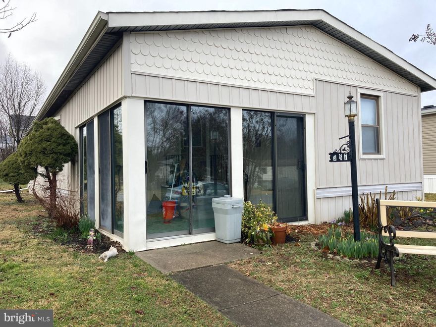 This freshly painted, newly carpeted 2 bedroom/2 bath home is move-in ready!  This home features an enclosed porch with a brand-new carpet that keeps you safe from the elements as you enjoy your morning coffee and keep an eye on the neighborhood.  The familiar Wayne model showcases a spacious Great Room with a cathedral ceiling and beams and shades on all windows that allow the flexibility you need to make it your own.  This room opens up to a sizable dining room with the furniture included.  The functional eat-in kitchen has multiple cabinets, counter space, and a food pantry along with your major appliances. The huge primary bedroom is just off the dining room and has an ensuite bathroom with a double sink, large closet, and shower stall.  The second bedroom is at the front of the home with two closets and an updated hallway bathroom with a step-in shower stall.  A laundry room is just off the kitchen and includes a washer and dryer with storage space.    Most of the furniture is included in the sale.  Come see this affordably priced home and get ready to settle in time for spring!