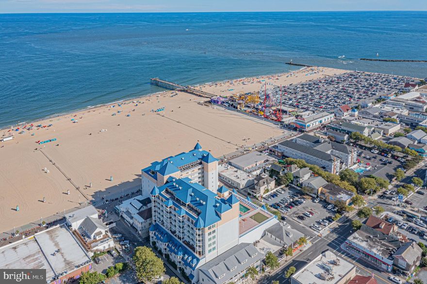 Breathtaking five star guest rated direct ocean, beach & boardwalk front corner condo in Belmont Towers with fantastic ocean views from every room and walkout access to the full length balcony from every bedroom plus the living room.  Enjoy spectacular panoramic beach, boardwalk and ocean views through glass sliders and all new crystal clear windows from every room of this exceptional refreshed  corner condo in Belmont Towers with strong rental history ($85,000 gross for the 2024 and 2023 season self managed through Air Bnb and VRBO even with two owner use weeks and is currently nearly booked for the 2025 season through OC Beachfront Rentals with a net rental contract in place for 2025 that transfers to the new owner (OC Beachfront Rentals manages rentals, cleaning, linens and maintenance up to $250 so all you have to do is collect the net rental payments if investment is your primary focus).  This unit has the potential to do between $95,000 and $100,000 plus in gross rental income self managed if desired or continue with the current net rental contract; the current owners have preferred to use two owner weeks both of the last two years. This bright sun-lit condo and its furnishings  were refreshed during 2022 through 2024; with many updates to the condo as well as all of its furnishings, is fully stocked in every way and has been meticulously maintained.  With 3 bedrooms (5 beds including a King suite with a spa like bath that has a rainfall shower, Queen guest bedroom, and a Bunk bedroom with a full, twin and an additional twin trundle, plus an additional pull out Queen Sleeper in the living room), 2.5 baths and an open functional and spacious layout in the best location in town.  This condo is sure to please every size group from smaller families to larger groups for all types of vacation, holiday or other gatherings. Watch an ocean sunrise over the beach from the balcony while enjoying a morning coffee and end the day with sunset views over the bay with a glass of champagne.  Sleep listening to the sound of waves crashing on the shore.  Watch the Dorchester St fireworks, Oceans Calling or Country Calling concerts and other events, or dolphin and people watch right from the comfort of your balcony.  There is a rooftop pool that  is located on the 12,500-Sq Ft sun deck that has a putting green and picnic tables, and there is also a fitness center, sauna and more. Park your cars in the two reserved owner spaces in the gated parking garage with elevators and luggage carts available for added convenience and walk to everything including the world famous boardwalk and Jolly Roger's pier, restaurants, water sports, shopping, mini golf and more.
