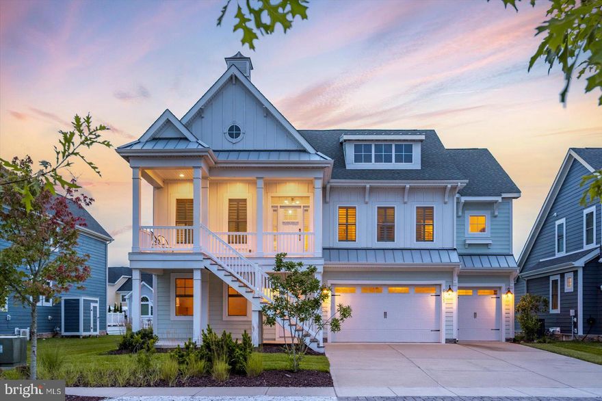 Nestled in the highly desirable Eastpoint Beach enclave of the resort-style Bayside community, this stunning coastal retreat blends sophisticated luxury with laidback charm. Offering four spacious bedrooms and four and a half baths, the home features soaring ceilings, whitewashed hardwood floors, shiplap wainscoting, painted beams, and an abundance of natural light.   With a reverse floor plan, the main living area is located on the second floor, providing privacy and sweeping views of the tranquil pond and fountain. Step onto the expansive covered veranda with a built-in grill and sink. Perfect for quiet morning coffee and sunset gatherings.   Back inside, the open concept allows for entertaining ease.  The chef’s kitchen is a stunning expression of coastal charm, featuring a gas cooktop and wall oven, premium stainless steel appliances, quartz counters,  island, walk-in pantry, ample counter seating, and counter space for prepping large meals.  The sizeable dining area with large windows overlooking the veranda makes hosting a true delight. The spacious, light, and bright family room with upper windows and a gas fireplace couldn't be more comfortable. The primary suite is the perfect ending to a beach-filled day with dual walk-in closets, a luxurious spa-inspired bath with two vanities, a separate water closet, a soaking tub, a tiled walk-in shower, and private access to the laundry room. The versatile front bedroom with French doors and its own private bath currently serves as an office, while the lower level offers two additional guest suites, one with an en-suite bath, and another conveniently near the second full bath. The 1st floor den has custom-built-ins, a wet bar with a beverage fridge, and large windows. Access to the screened porch with easy breeze windows and the outdoor covered patio.  Access to the oversized three-bay garage is also on this level. This oversized homesite is just steps away from The Point with the 38 Degrees Coastal Eatery, crabbing, and fishing pier, kayak launch, and paddle boarding. Bayside boasts unparalleled amenities that include a health and aquatic club, indoor lap swimming pools, a state-of-the-art fitness center, and a sauna.   Outdoor swimming pools with splash zones, hot tubs, poolside bar/grille, Basketball, tennis, and racquetball courts, and playgrounds. Take the beach shuttle, lounge on the bayfront beach, listen to live performances at Freeman Stage, and walk or bike on the many trails available. With multiple porches, ample space for all, proximity to all of the amenities that Bayside offers, and its location less than 5 miles to the magnificent beaches of Fenwick Island and Ocean City, makes this special home more than just a beach house.