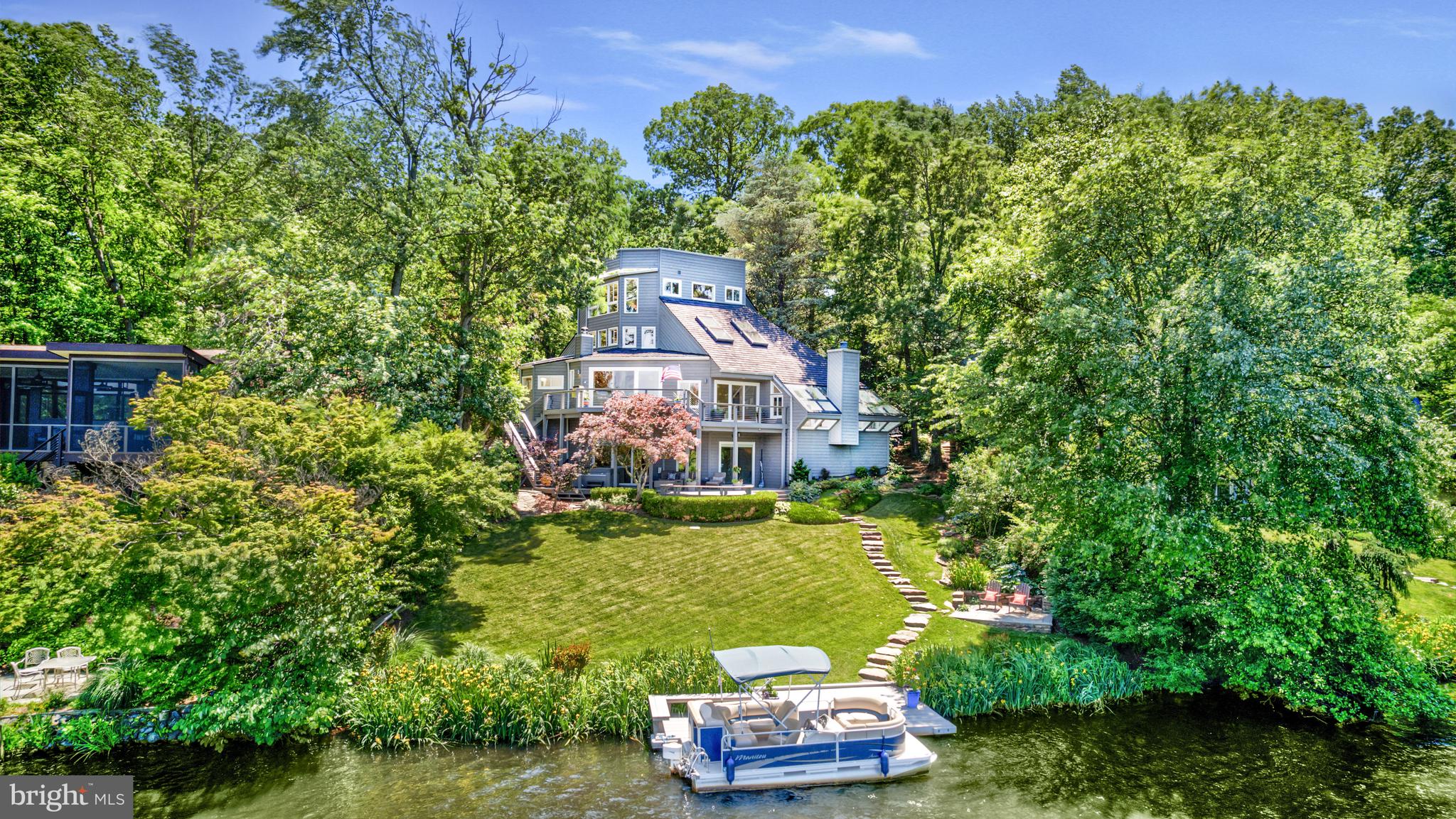 Welcome to 2200 Spinnaker Court! Get ready to enjoy 180-degree waterfront views at the center of Lake Audubon! Your private dock & pontoon boat await! This 4 bedroom, 3 1/2 bath contemporary home is perfectly situated in South Reston AND Lake Audubon. With 6,000 square-feet, this home has great space to suit your individual lifestyle. MAIN LEVEL: The main level has newly refinished hardwood floors throughout, & new hardwoods in the living room & in the conversation pit, next to the living room. From the moment you step into the foyer, you know you are in a special home, with a fun, contemporary design, an abundance of windows, skylights & sliding glass doors & AMAZING lake views of Reston's 44-acre Lake Audubon. The Velux skylights in the living room have a rain sensor & will shut automatically (just in case it starts to sprinkle while you are on the boat!) The conversation pit offers built-in seating, a gas fireplace & an incredible set of skylights & windows (all were replaced with double pane windows 6 years ago). This is a great place to actually have a conversation, read, relax & enjoy more water views. Every meal in the dining room is special with views of the lake-& the bald eagles, osprey, cormorants, hawks & herons frequent the skies & shoreline providing terrific glimpses of nature. You can access the spacious, main level deck from either the dining or living room sliding glass doors. The cable railing allows you to enjoy additional views of the water & nature by not blocking the view. The kitchen has granite counters, stainless steel appliances, gas cooking, AND great views of the lake while you are preparing meals! There is also a breakfast room which could be a small family room which is open to the kitchen. The laundry room, with access to the garage (with new, Epoxy floors), & the powder room (completely remodeled in May 2025) are also on this level. The garage has a ton of cabinet space, including cabinets with pull-out drawers for easy storage. UPPER LEVEL 1 has a fun loft which overlooks the living room. There are plenty of built-in bookcases in this space, & also great natural light. Bedrooms #2 & #3 are on this level, and Bedroom #2 has built-in bookcases, a walk-in closet, & access to the walk-in attic. The bedrooms share the full hall bathroom (remodeled in May 2025). UPPER LEVEL 2: This level features the primary suite. The views of the lake are incredible, whether first-thing in the morning, or as the sun is setting at night. The bedroom has walls of windows, hardwood floors & a small wet bar, complete with a Subzero refrigerator/freezer. The primary bath has a floating counter with double vanity sinks & a large wall mirror. There is a large, soaking tub & a separate, walk-in shower with stone. Other features include a linen cabinet, heated floors & a walk-in closet with built-ins. Pull-down stairs access the rooftop deck. FULLY-FINISHED WALK-OUT LL: This space is perfect for everyone! The high ceilings are the first feature that will catch your eye, but then it's the oversized sliding glass doors & large windows, the new (May 2025) LVP flooring, the wine storage closet under the stairs & the access to the covered, lower-level deck. Bedroom #4 is on this level, & features 2 closets, plus an additional space which could either be a large closet or flex space. The full bath on the LL (2019) features a walk-in shower, floating vanity, & heated floors. OUTDOOR SPACE: 2 large decks-the main level deck & the covered LL deck- are connected by a nice, wide staircase. The covered deck is perfect on rainy days...you can jump in the hot tub without being in the rain or snow, or sit outside & read, it's a great retreat. Stone steps lead from both sides of the home & from the LL deck to the composite dock & the pontoon boat (which will convey). There is also a stone patio next to the dock for casual entertaining. New Roof ('24). New stair railings, 2 New HVACs , all interior paint, all new carpet (2025).