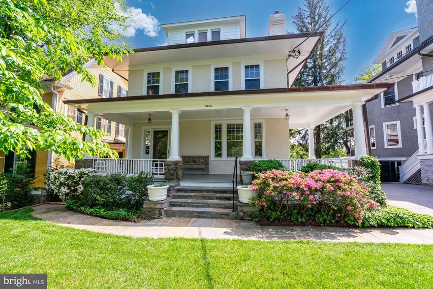 3214 Newark offers two combined lots, totaling .23 acres, and approximately 6,000 sqft of interior space. The house is located on one of Cleveland Park’s most coveted tree-lined streets, embodying classic elegance and historic character. Set gracefully behind a lush front lawn and accessed by a stone walkway, the residence welcomes you with an expansive front porch. Inside, a gracious foyer introduces light-filled, beautifully scaled rooms that showcase the home’s original craftsmanship, including crown moldings, intricate millwork, high ceilings, and preserved hardwood floors. The inviting living room centers on a detailed fireplace and built-ins, opening through pocket doors to a grand dining room distinguished by warm wood paneling and a striking coffered ceiling. An adjoining sitting area overlooks the lush terrace and gardens, creating a seamless connection between indoor and outdoor living. The kitchen offers a suite of stainless steel appliances, generous cabinetry and an inviting breakfast area with access to the rear yard, providing an ideal flow for al fresco dining. A nearby powder room adds convenience and completes the main level. Upstairs, the sun-filled primary suite features floor-to-ceiling built-in bookshelves, a walk-in closet, and an elegant office or sitting room with a fireplace and is further enhanced by an en-suite bathroom. Two additional bedrooms on this level share a hall bathroom, and a dedicated laundry room completes the floor. The third level offers two spacious bedrooms, one with skylights and another with a fireplace and panoramic treetop views, along with a flexible room ideal for a study, playroom, or creative space. The expansive lower level provides exceptional potential for customization with abundant space for a recreation room, gym, wine cellar, or guest suite. Outside, the grounds unfold into a private garden sanctuary. A gracious upper terrace is ideal for entertaining and dining, while a stone staircase leads down to a lower garden surrounded by mature trees, lush plantings, and a tranquil fountain. Perfectly sited within close proximity to Cleveland Park’s cherished amenities, this distinguished residence offers easy access to Rock Creek Park and the Tregaron Conservancy, as well as the shops and restaurants along Connecticut and Wisconsin Avenues, Cathedral Commons, and the Metro. The neighborhood’s proximity to the National Cathedral Schools, John Eaton Elementary, and Sidwell Friends School further enhances its appeal as one of Washington’s most desirable residential settings.