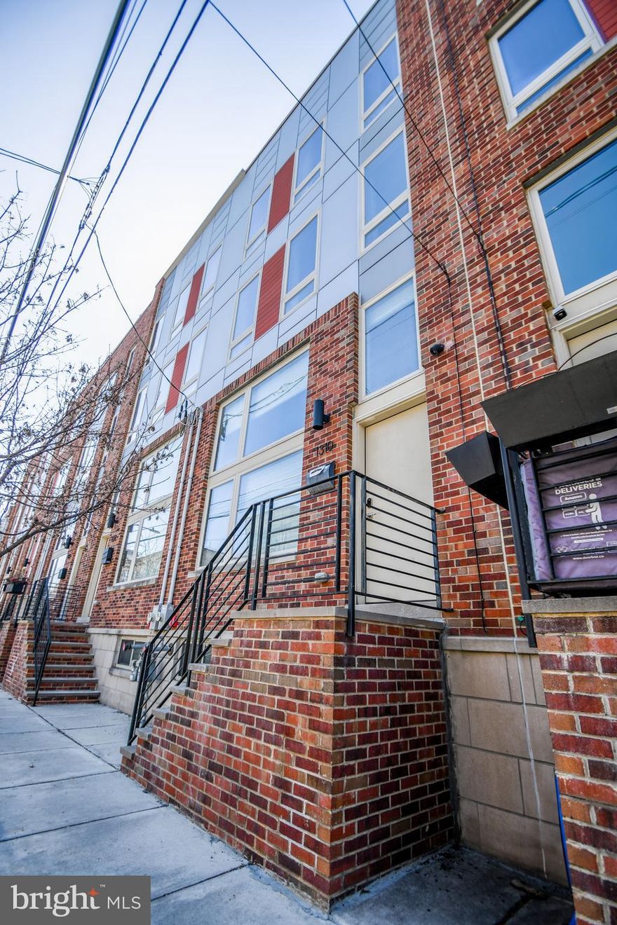 Welcome to 1310 S. 20th Street — a luxury townhome, built in 2018, is a stunning combination of comfort and style, with a private roof top deck,  approximately 2 years left on the tax abatement, and with rare private gated garage parking with interior access—a true luxury in this sought-after neighborhood at Wharton Place in the heart of South Philly!

Step inside to find a bright and airy living/den space with 14 foot ceilings and tons of natural light. Up a few steps you enter the inviting kitchen and dining area. The kitchen boasts stainless steel appliances, waterfall island countertop, dishwasher, double door refrigerator, quartz countertops, and more than ample cabinets perfect for every day meal prep and entertaining. The thoughtfully designed layout flows seamlessly into the dining space that overlooks the lower level living room through a sleek glass wall that reeps all the benefits from the natural light coming through the large front windows.  Next to kitchen is a guest half bathroom. 

Upstairs, you’ll find 2 spacious bedrooms with great extra large windows for tons of natural light and custom closet systems. Nestled between the bedrooms is the first of 2 full bathrooms. This floor also houses the laundry closet with almost new washer and dryer applicances in place.  The third floor hosts the primary suite with custom walk in closet and a spa like bathroom with a dual sink vanity. The suite can be closed off for added privacy. This floor also has a guest half bath just before heading up to the roof top deck. Yep! Your own private deck with amazing views of the beautiful City skysline. This outdoor space provides an ideal setting for morning coffee, weekend barbecues, or simply unwinding after a long day. 

But wait there is more... the lower level is a full finished basement with interior access to the garage and additional living and closet space with recessed lighting.

Located just minutes from all of the City's finest parks, shopping, hospitals and universities, and public transportation, this home places you in the center of it all while still offering a quiet residential feel.

Don’t miss your chance to own a home that checks all the boxes—schedule your showing today and experience everything 1310 S. 20th Street has to offer!
