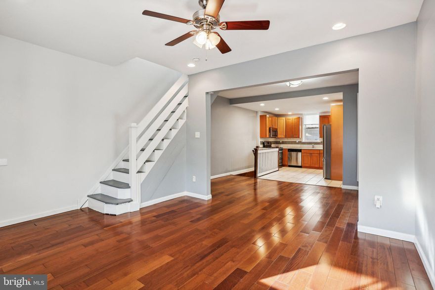 Welcome to this charming rowhome in the heart of Cobbs Creek! Enter from the inviting front patio and covered porch into an open-concept floor plan. The main level greets you with beautiful wide-plank hardwood flooring, recessed lighting, and a large front window that fills the space with natural light. The living room seamlessly flows into the dining area, which then opens to the updated kitchen, complete with sleek Quartz countertops, a stylish porcelain tile backsplash, and stainless steel appliances. A door from the kitchen leads out to a cozy back patio, perfect for relaxing or entertaining. Upstairs, you'll find durable Pergo laminate flooring throughout the three bedrooms. The front-facing primary bedroom boasts a large bay window and updated decorative mirror closet doors, while the back bedroom features dual closets for ample storage. All bedrooms share a beautifully updated full bathroom in the hall. The finished basement offers additional living space, ideal for a family room, office, or play area, and also includes the laundry area and a convenient half bathroom. A new hot water heater was installed of February 2023. Located in a highly desirable area, this home is just a short distance from local schools, a SEPTA station, Morris Rec Center, the free public library, and shopping centers. It’s also only a few blocks away from Cobbs Creek Park, offering an array of outdoor activities including biking and hiking trails, a baseball field, basketball court, and an ice skating rink. This is the perfect combination of comfort, convenience, and location!