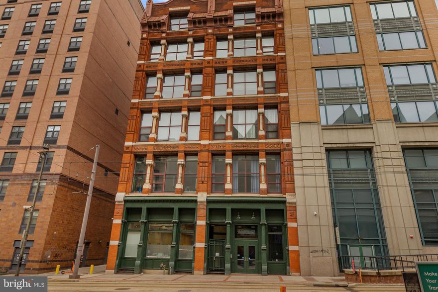 A rare Downtown Baltimore residence where historic architecture meets elevated city living. Set within a fully restored landmark building in the heart of the Bromo Arts & Entertainment District, this prime rear corner unit offers an exceptional blend of privacy, light, and timeless character. With southern and southwestern exposure, the home is filled with warm natural sunlight—and crowned by its signature feature: a grand arched window (the only one in the building) that frames a striking, uninterrupted view of the celebrated Bromo-Seltzer Tower (constructed in 1929).

Inside, 12-foot ceilings amplify the sense of scale and openness while allowing lighting and design elements to shine. The living and dining areas feel expansive yet welcoming, enhanced by recent improvements: new oak laminate flooring (12/2025) throughout most of the home (excluding the 2nd bedroom/den), and refreshed surfaces in the living/dining room, including the ceiling and corner walls. The primary bedroom has been thoughtfully updated with new paint on the ceiling and two walls (8/2025) for a clean, modern finish.

The residence comes with all appliances and key updates for comfort and confidence, including a 50-gallon professional-grade water heater (9/2021) and a new toilet (2022). The condo fee supports a streamlined lifestyle, covering heat and hot water, building common-area insurance and maintenance, and trash removal. Select extras are included: living/dining chandelier lights plus furnishings in the 2nd bedroom/den, including a king sleeper sofa, wardrobe, and 70” TV—a turnkey bonus for flexible living.

From your front door, enjoy immediate access to Baltimore’s most dynamic destinations: Light Rail directly out front, Camden Yards, MARC station, Inner Harbor, Lexington Market, CFG Bank Arena, and the Hippodrome blocks away—plus effortless connectivity to I-395, I-95, and MD 295. Distinctive, sunlit, and truly one-of-one—schedule your private tour today.