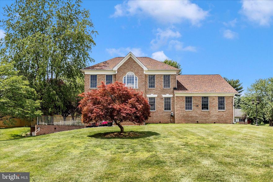Tucked away on a picturesque, level 1.13-acre lot in the Clearview community, this custom-built brick front colonial offers over 4,000 square feet of beautifully finished living space—where timeless design meets thoughtful, high-impact updates.

A grand two-story foyer makes an unforgettable first impression, highlighted by Italian Carrara marble flooring that continues seamlessly into the kitchen and half bath, and a dramatic custom wood feature wall that elegantly follows the staircase for a truly one-of-a-kind architectural statement. The main level is both refined and functional, offering a dedicated office with built-ins, formal living and dining rooms, and a beautifully updated kitchen (2020) featuring white shaker cabinetry, granite countertops, and stainless steel appliances.

Just beyond, the sunken family room is the heart of the home—anchored by a striking custom wood-burning fireplace, framed by floor-to-ceiling dry stack stone, and enhanced by vaulted ceilings and skylights that flood the space with natural light.

Upstairs, four generously sized bedrooms include a spacious primary suite with a walk-in closet, dual vanities, and a soaking tub designed for relaxation.

The fully finished walkout lower level adds exceptional versatility with a full second kitchen, full bath, and multiple living areas, creating an ideal setup for multi-generational living, extended guest stays, or private retreat space.

Step outside to a truly special backyard—level, expansive, and park-like—featuring a large, covered patio for year-round enjoyment along with an additional brick patio, perfect for entertaining or quiet evenings at home. Beautiful mature trees grace the landscape featuring 13 various fruite trees (peaches, plums, pecans and apricots)

Major updates include a new roof and septic fields (2020), offering peace of mind for years to come. A side-entry two-car garage, main level laundry, and a private yet convenient location near I-70, I-270, Downtown Frederick, shopping, dining, and parks complete the offering.

A rare combination of custom detail, flexible living, and serene outdoor space—this is a home that truly stands apart.